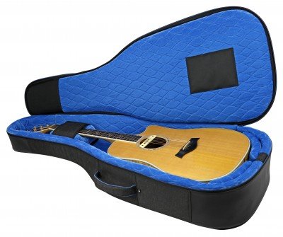 A Reunion Blues Voyager AC/Dread Guitar Bag (RBCA2) rests open, showing blue quilted padding. This soft-shell case features a side handle and shock-absorbing materials for extra protection.
