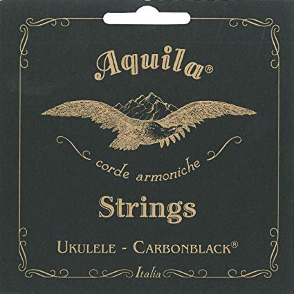 The Aquila Carbonblack (143U) Tenor Ukulele Strings feature a gold eagle and mountain design, ornate borders, and English/Italian text on a dark background—a stylish choice from Aquila for tenor ukuleles.