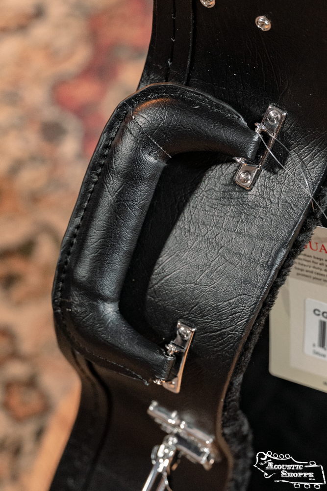Close-up of the Guardian CG-022-OOO Deluxe Hardshell Case-000 Style’s black leather handle with metal hardware and visible stitching—ideal protection for your guitar from Guardian.