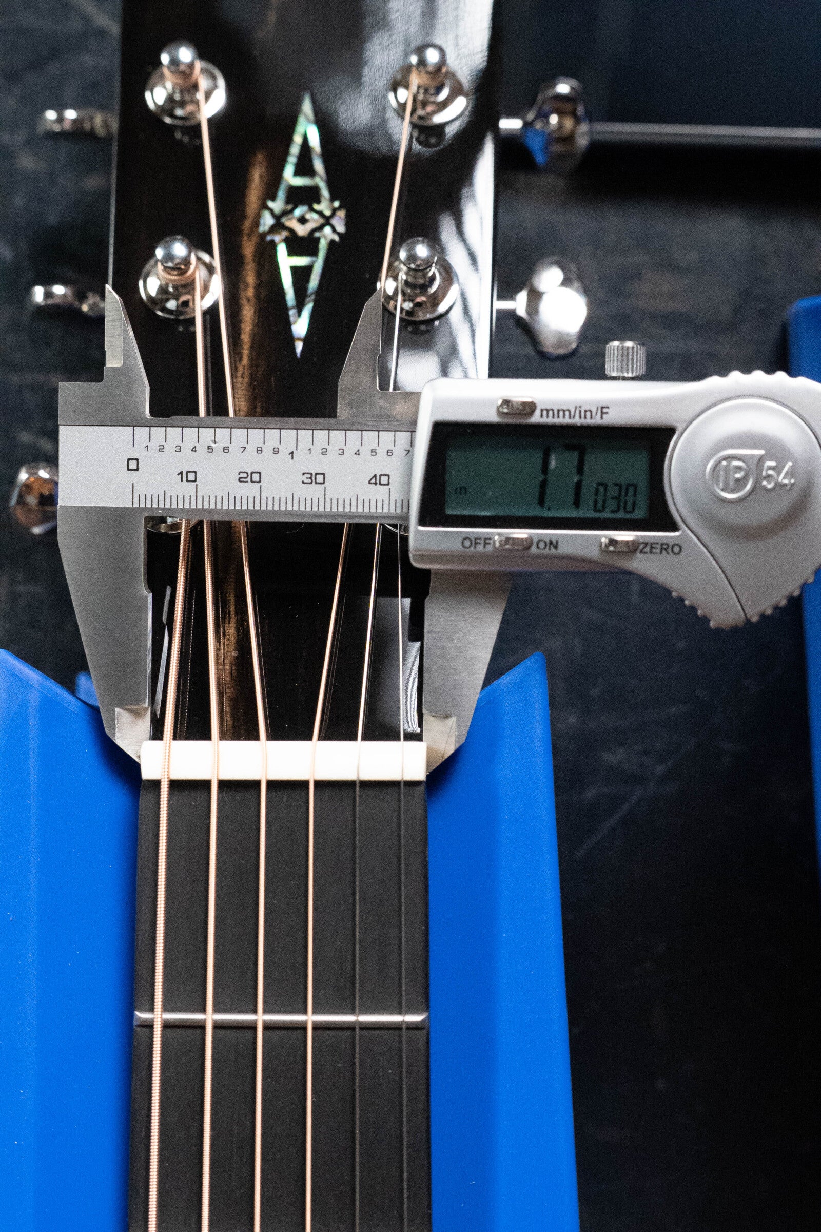 A digital caliper shows the Alvarez Laureate Series LD70e neck width above the nut as 41.03 mm. The Alvarez dreadnought guitar is secured by blue supports.