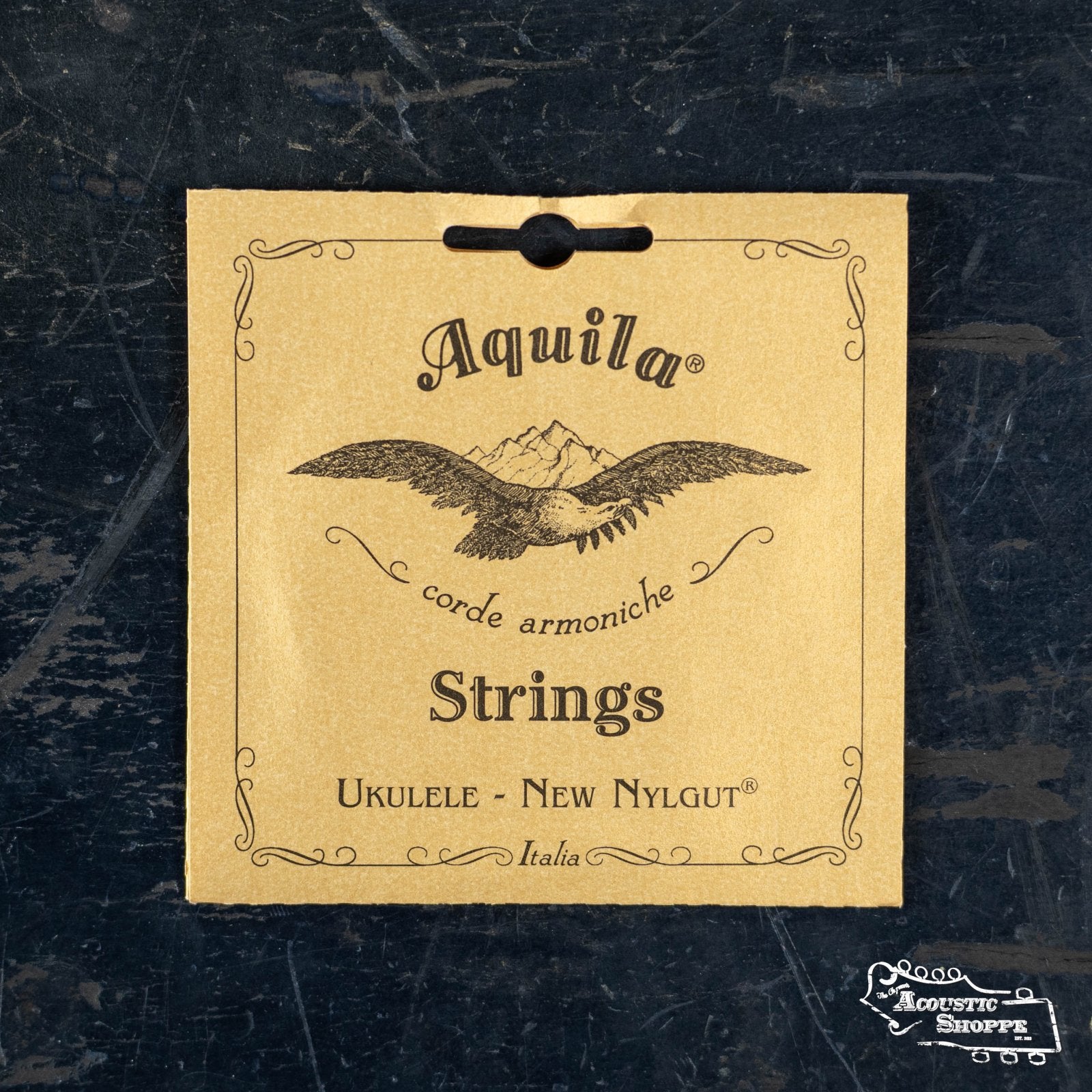 Aquila Nylgut (4U) Soprano Ukulele Strings by The Acoustic Shoppe offer accurate fret intonation and come in a brown paper bag featuring a bird, mountains, and decorative text.