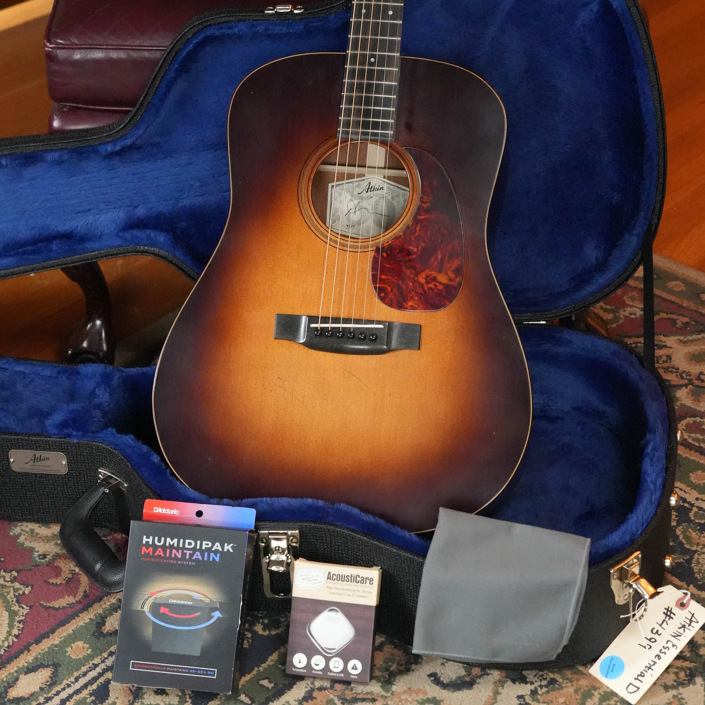 An Atkin Guitars Essential D 45MM Sitka/Mahogany Dreadnought Acoustic Guitar (#4399) with a sunburst finish rests in an open blue-lined case, accompanied by a gray pouch, D’Addario Humidipak, cleaning cloth, string winder, and white tag.
