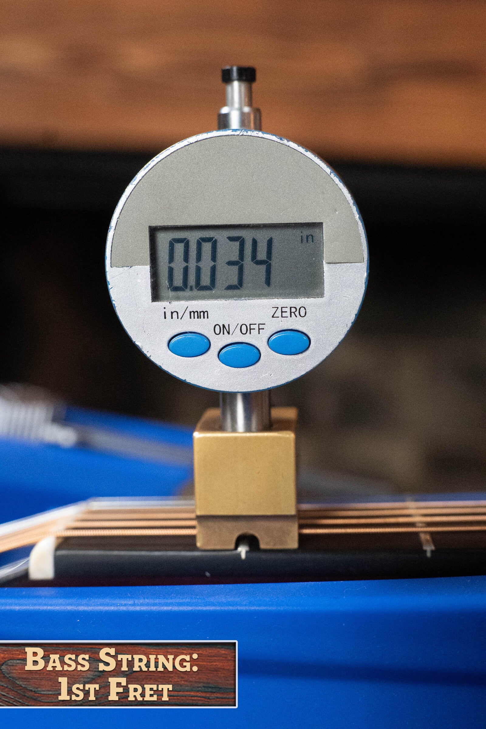 A digital gauge reads 0.034 inches measuring the string height at the 1st fret, ideal for setting up the Boucher BG-52-GM Torrefied Master Grade Adirondack Red Spruce/East Indian Rosewood Bluegrass Dreadnought by Boucher Guitars.