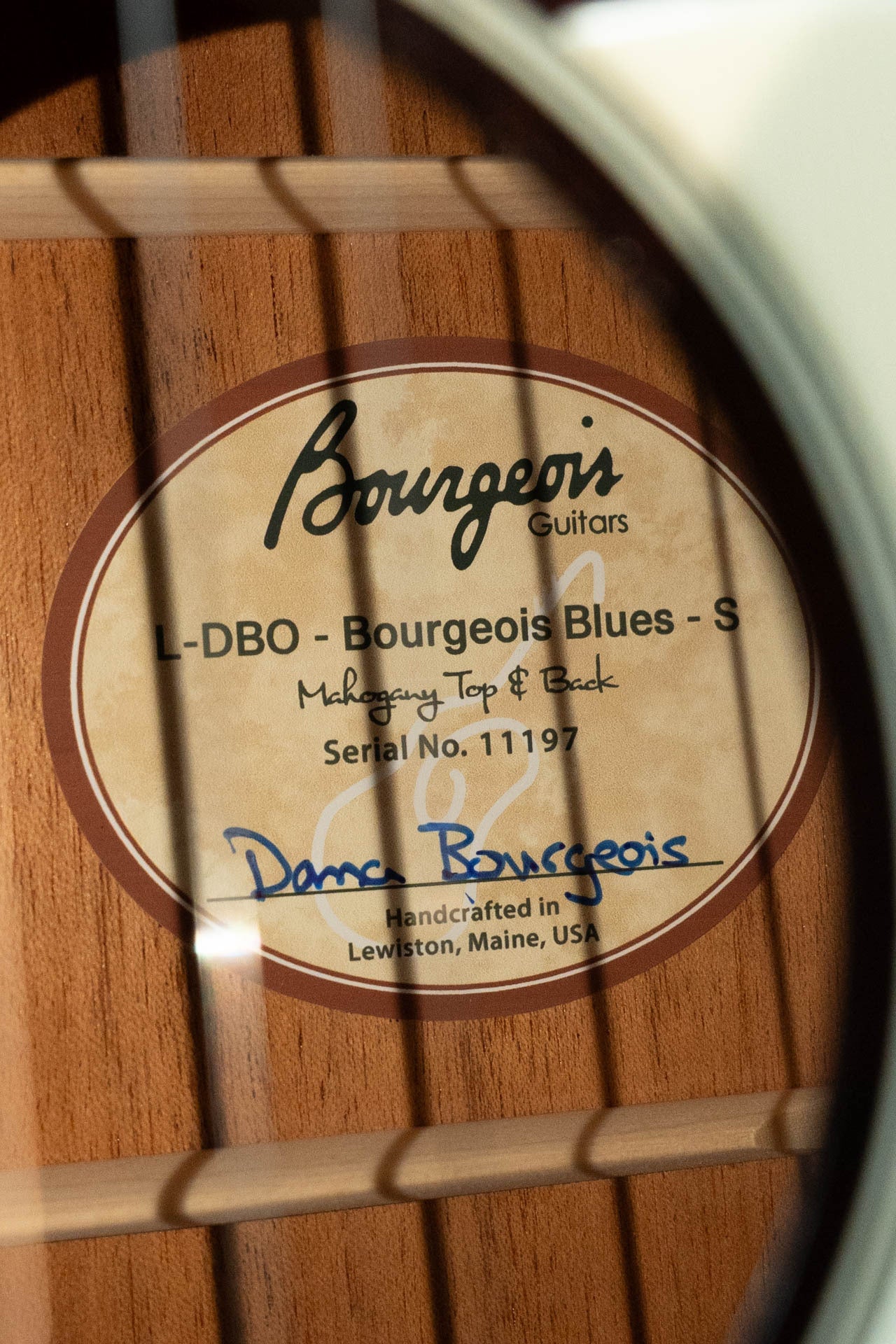 Close-up of the inside label of a Bourgeois Blues PSBB-LDBO-S Satin Professional Series All Mahogany OO Acoustic Guitar #1197, showing the signature and "Handcrafted in Lewiston, Maine, USA" printed below.