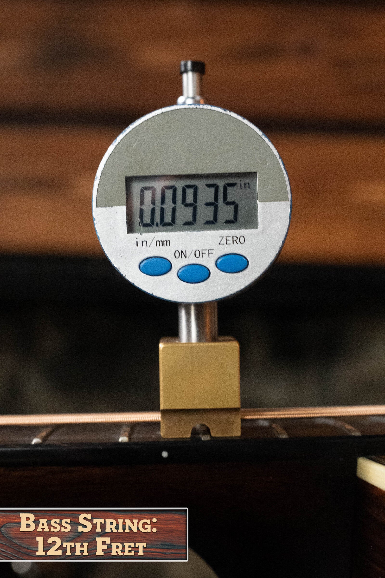 A digital gauge displays 0.0935 inches for the string action at the 12th fret of a Bourgeois D Vintage/TS Touchstone Series Dreadnought Acoustic Guitar #7014, with a label reading “Bass String: 12th Fret.”.
