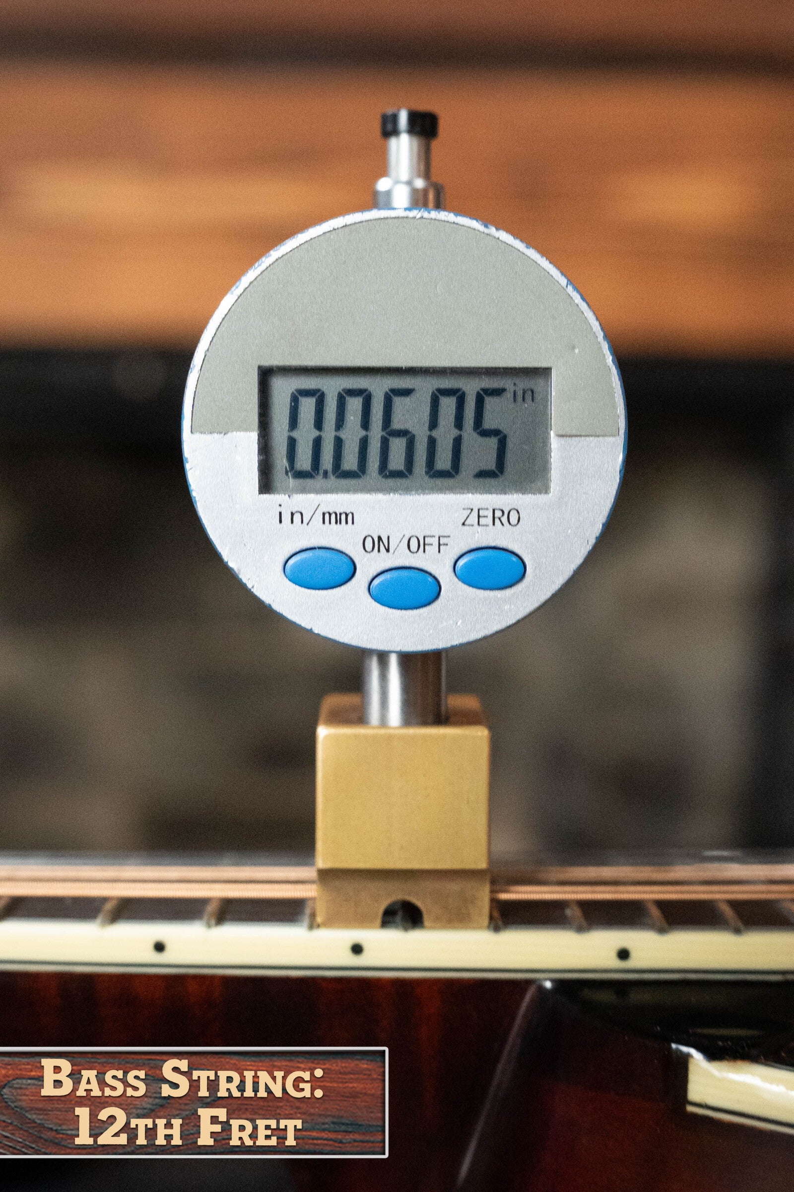A digital gauge shows the bass string height at the 12th fret is 0.0605 inches. The label reads Bass String: 12th Fret, referencing the Bourgeois M5-A-BT Aged-Tone Black Top A-Style Mandolin #2020 by Bourgeois.