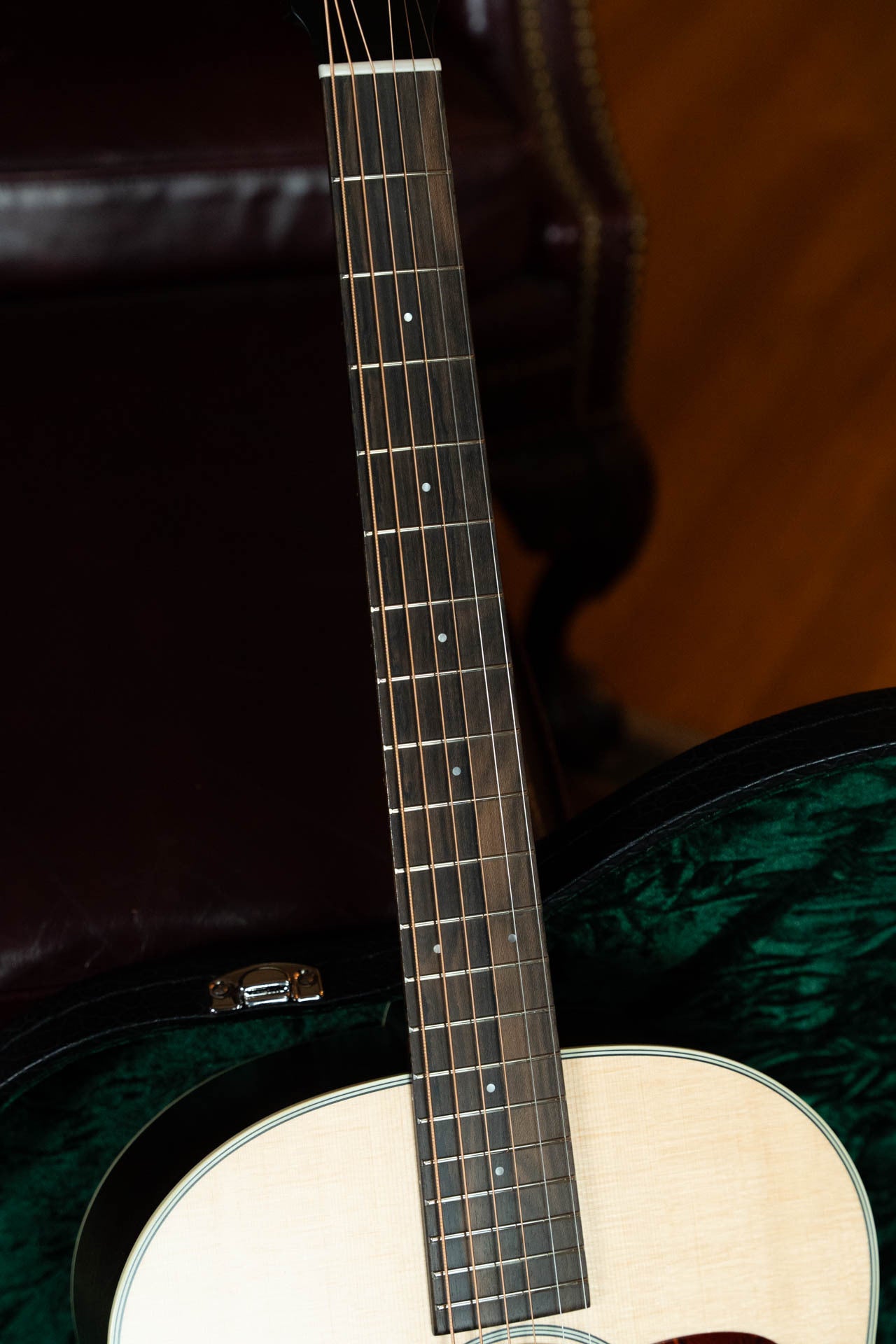 A close-up of the Boucher Guitars Bourgeois PSN-SD-S Satin Professional Series The Natural Sitka/Mahogany Slope Shoulder Dreadnought Acoustic Guitar #1174 shows its neck, fretboard with metal frets, dot inlays, Sitka spruce top, and dark green side.