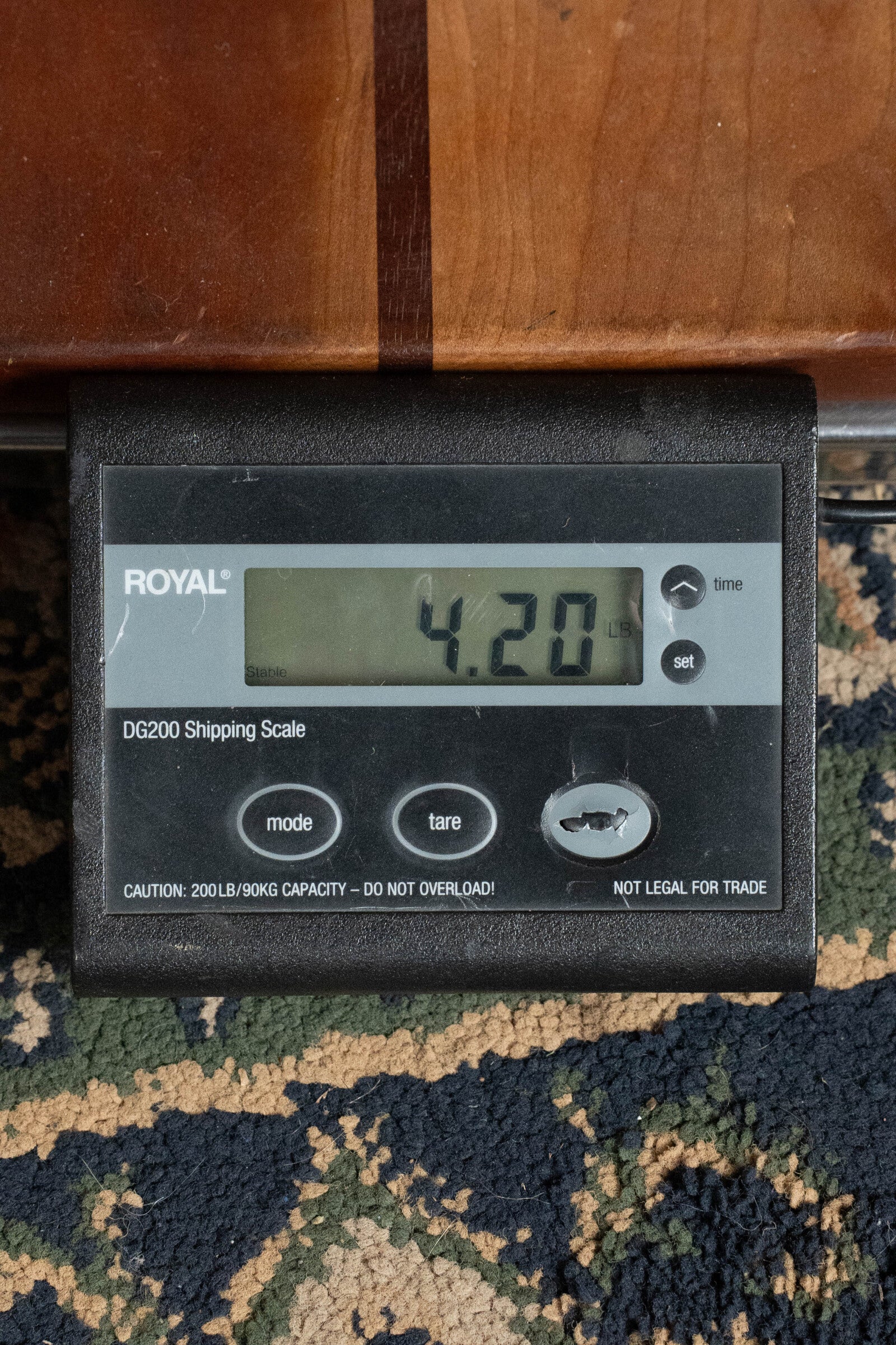 A digital shipping scale shows 4.20 lbs on patterned carpet under wood. The Royal DG200 brand is visible—ideal for weighing items like the Bourgeois PSV-D-S Professional Series Sitka/Rosewood Dreadnought Acoustic Guitar #1124.