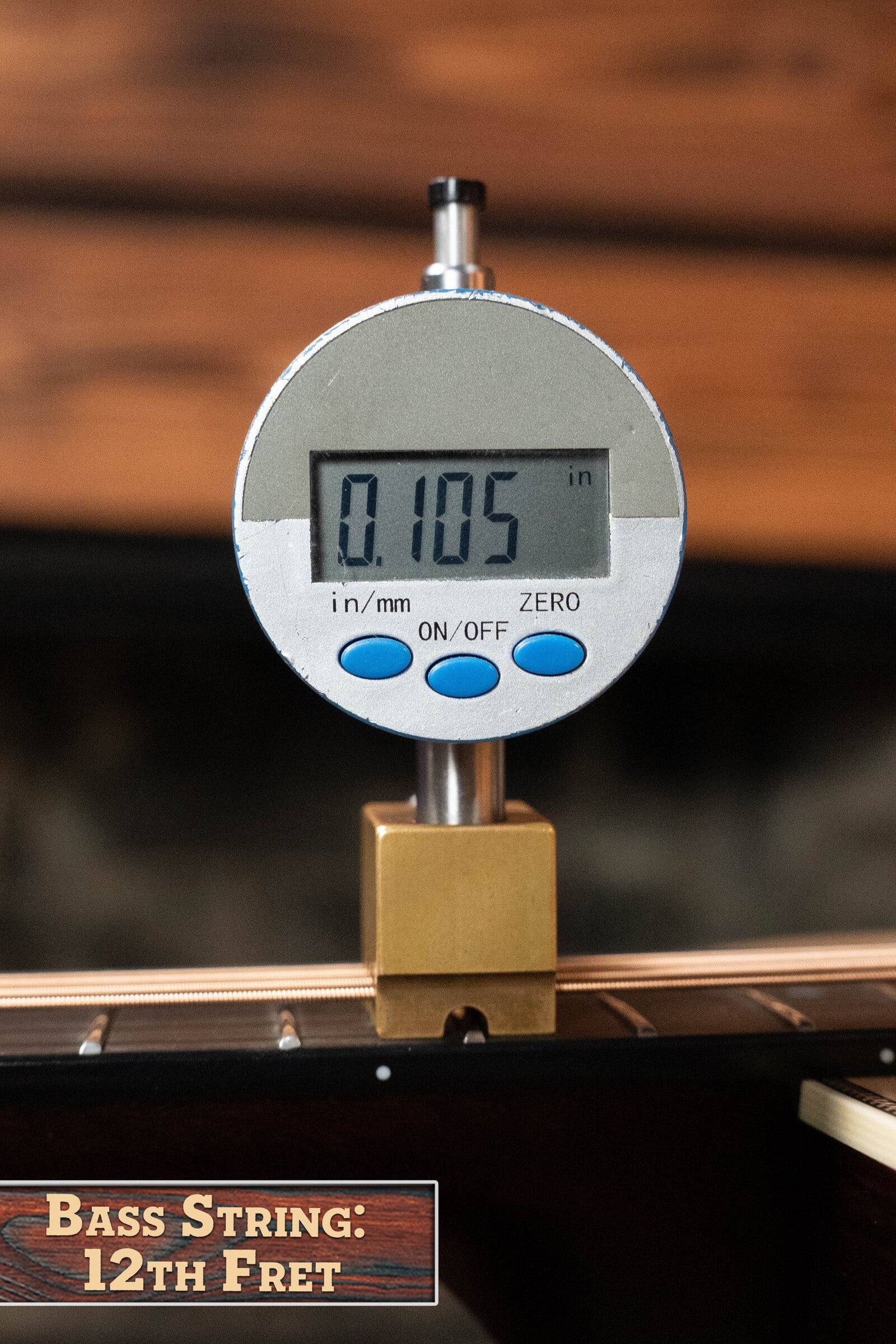 A digital gauge reads 0.105 as it measures bass string height at the 12th fret on a Bourgeois PSV-D-S Professional Series Sitka/Rosewood Vintage Satin Dreadnought Acoustic Guitar #1124.