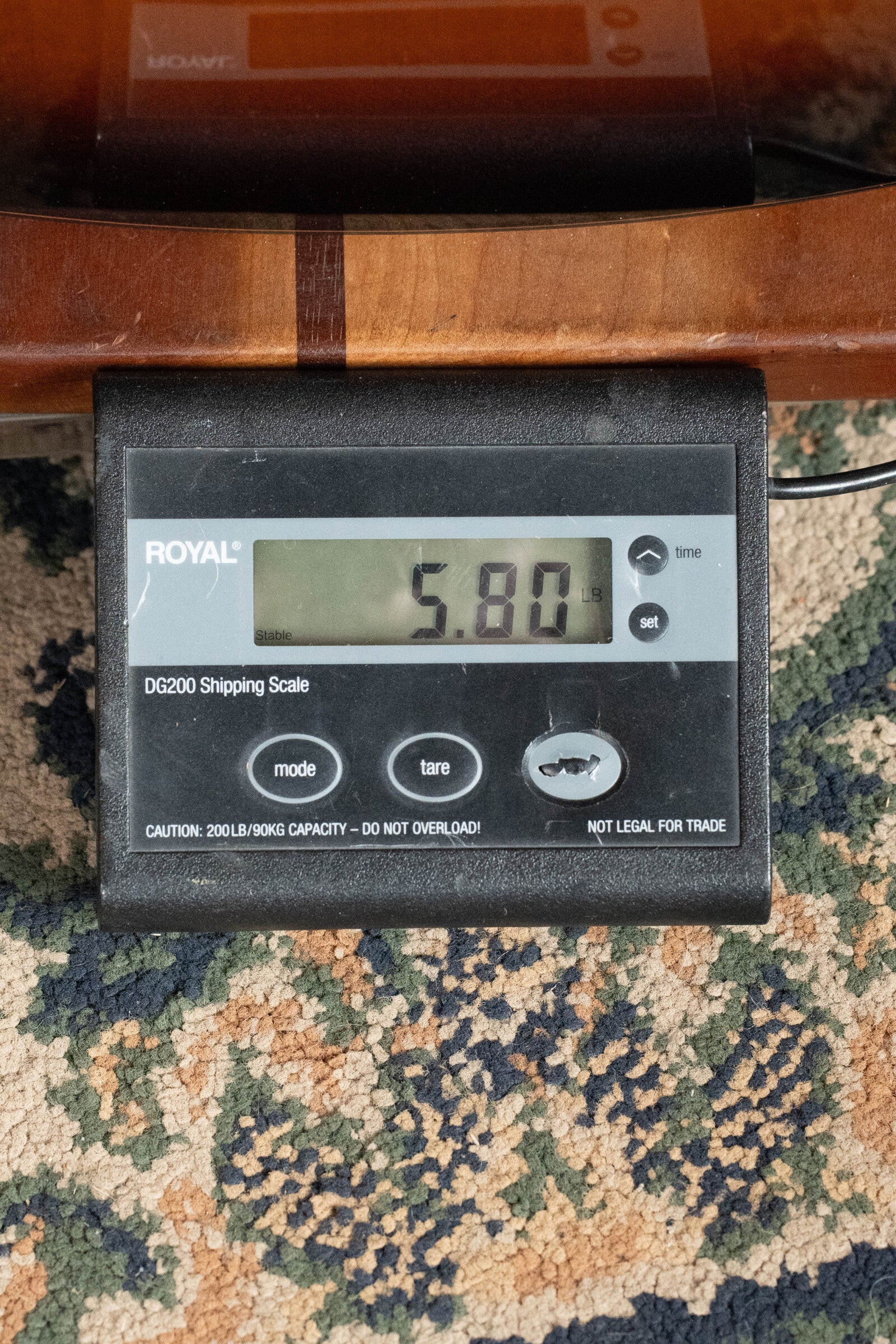 A digital scale (ROYAL DG200) on carpet shows 5.80 lbs as it weighs a Breedlove Organic Solo Pro Concerto Red Cedar/African Mahogany Edgeburst Cutaway Acoustic Bass w/ Fishman Pickup, ideal for rich acoustic bass tones.