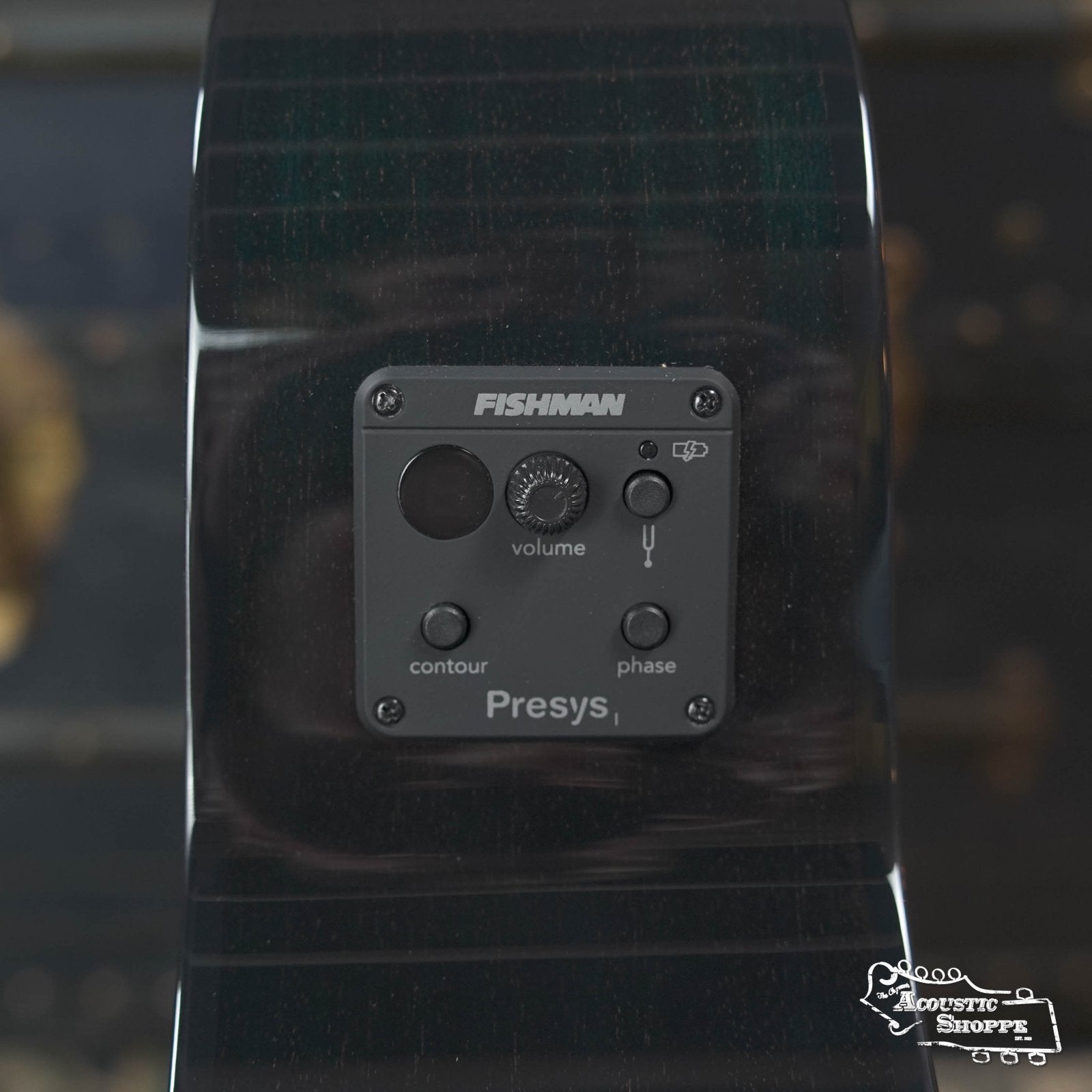 Close-up of the Fishman Presys I preamp panel on a glossy black Breedlove Rainforest S Concert Papillon All Mahogany Cutaway Acoustic Guitar, showing volume, contour, and phase controls. Features EcoTonewood tech for sustainability.
