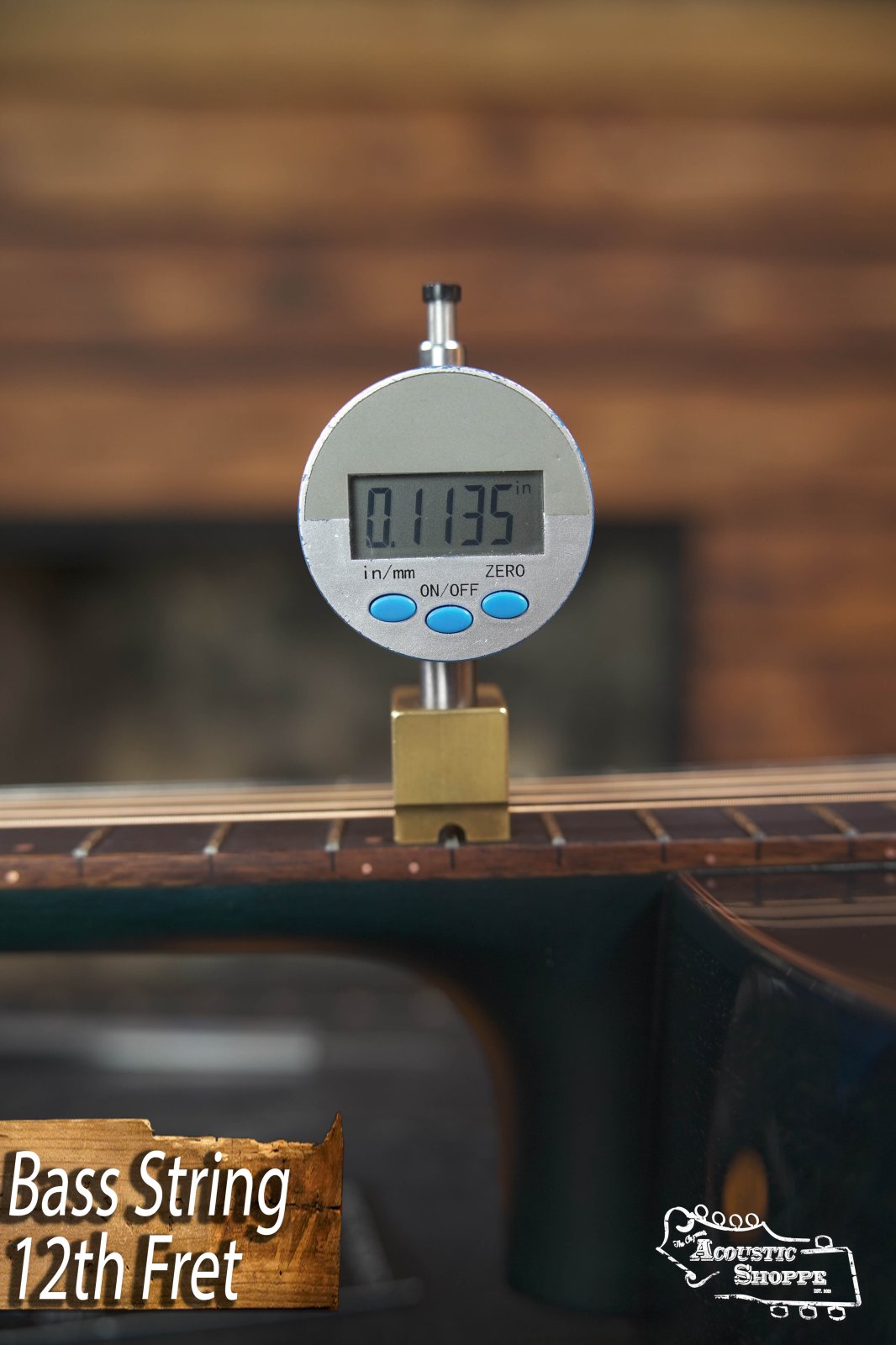 A digital gauge shows the bass string height above the 12th fret on this Breedlove Rainforest S Concert Papillon All Mahogany acoustic-electric guitar (#6534) as 0.1135 in. The screen reads “Bass String 12th Fret” with The Acoustic Shoppe logo.