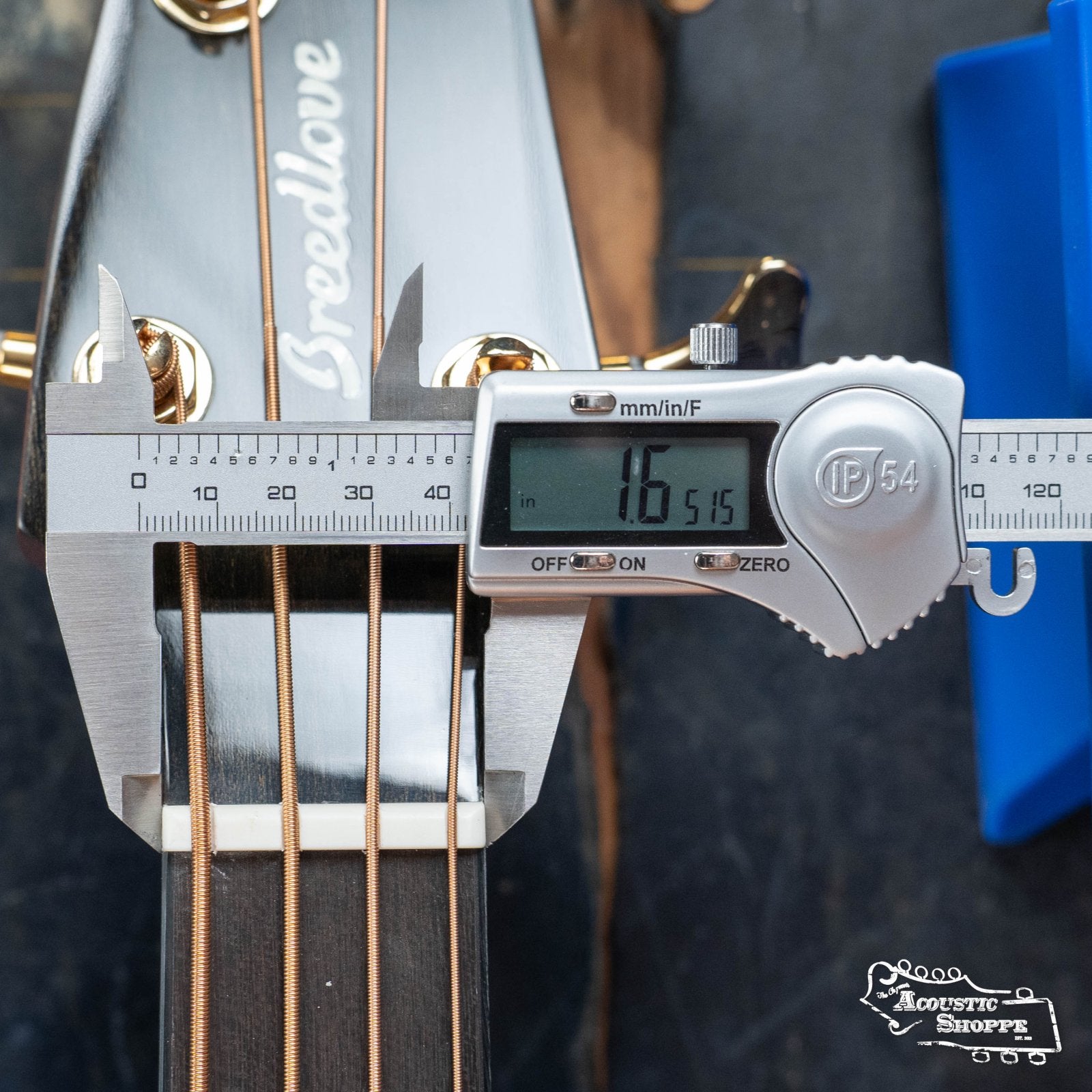 A digital caliper shows the Breedlove Organic Solo Pro Concerto Red Cedar/African Mahogany Edgeburst Cutaway Acoustic Bass neck width at the nut as 1.6515 inches; headstock, strings, tuning pegs, and Acoustic Shoppe logo are visible.
