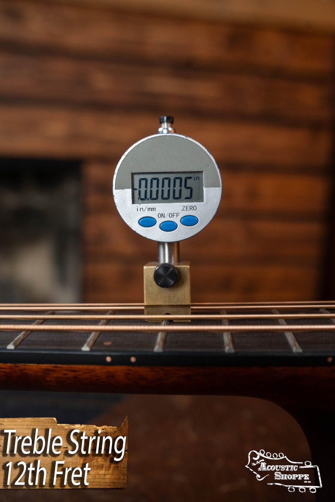 A digital gauge measures string height at the 12th fret of a Breedlove Organic Solo Pro Concerto Red Cedar/African Mahogany Edgeburst Cutaway Acoustic Bass w/ Fishman Pickup. Display reads 0.0005 in/mm, with “Treble String 12th Fret” shown and Acoustic Shoppe logo.