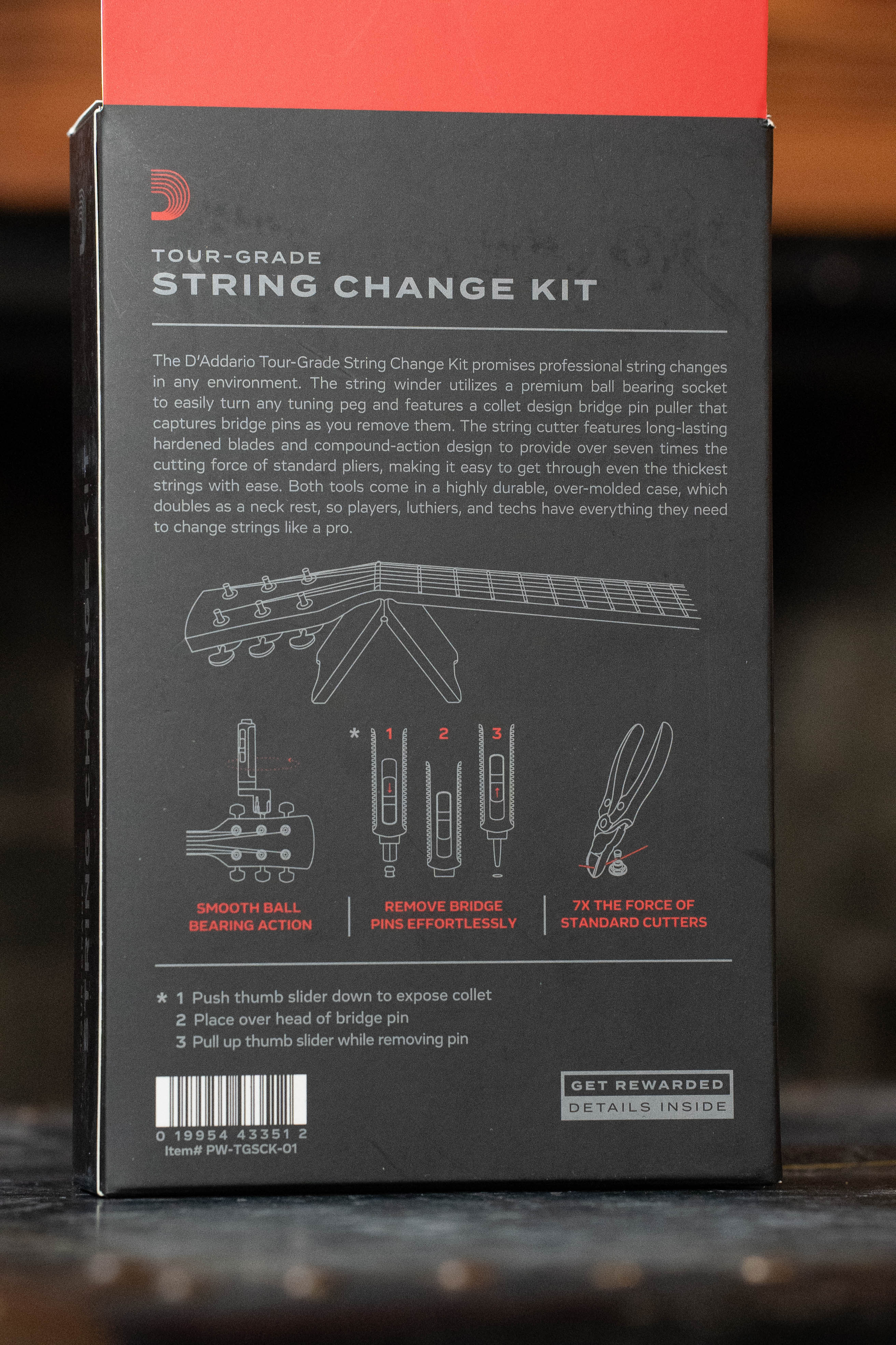 The back of a D'Addario Tour Grade String Changing Kit box features product info, diagrams for the bridge pin puller and string cutter, plus instructions and benefitsโall by DโAddario to make string changes easy.