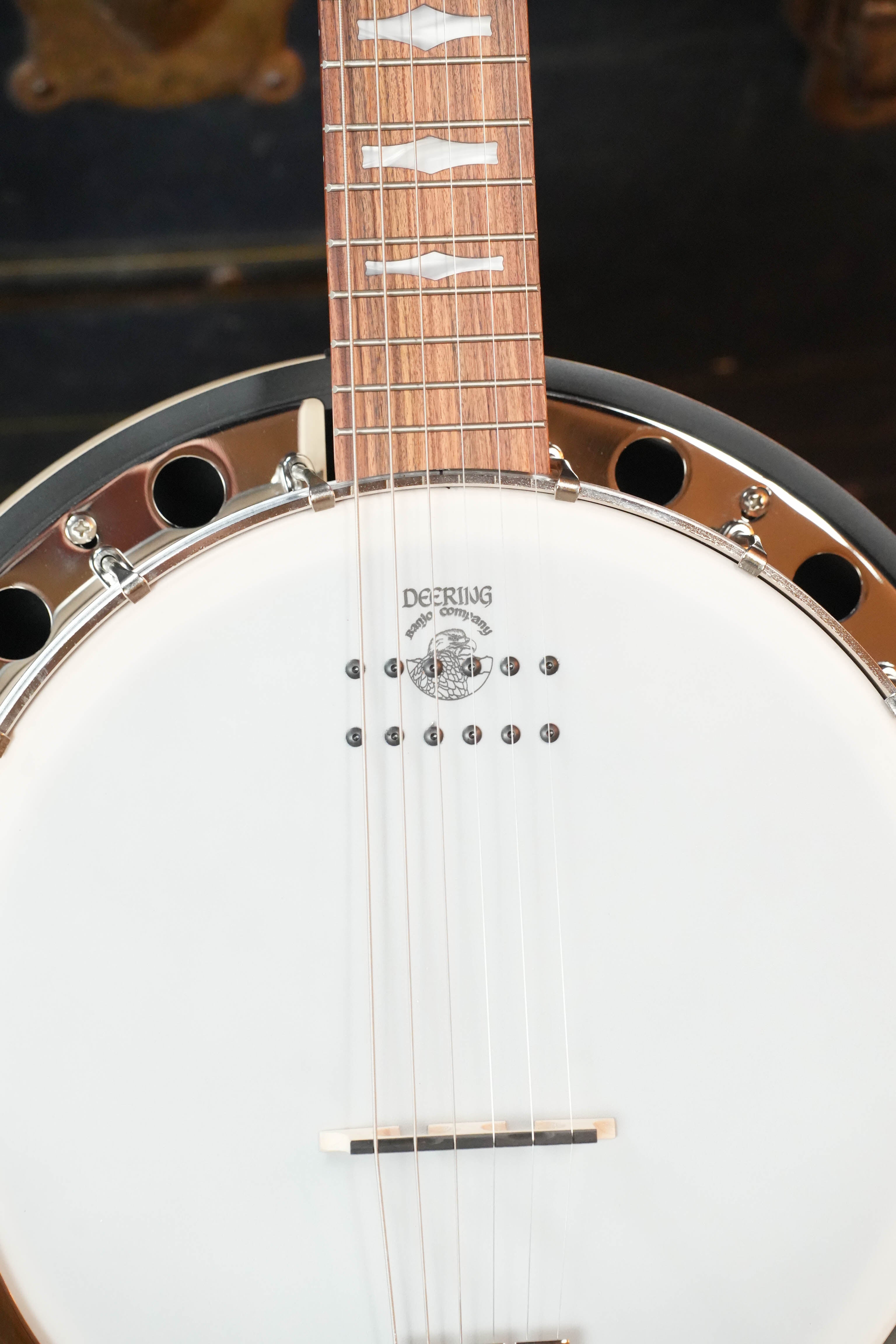 Close-up of the Deering Goodtime 6 R Steel String Banjo W/Kavanjo Pickup #2620 from Deering Banjos, highlighting its wooden neck, steel strings, white drumhead with visible Deering logo, and metal rim.