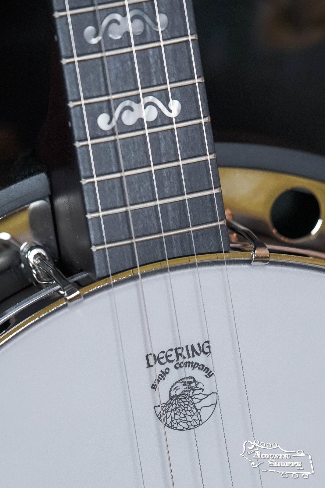 Close-up of a Deering Artisan Goodtime Two 5-String Banjo with Resonator (#8977) by Deering Banjos, featuring decorative fretboard inlays, the Deering logo on the drumhead, and a classic maple rim design.