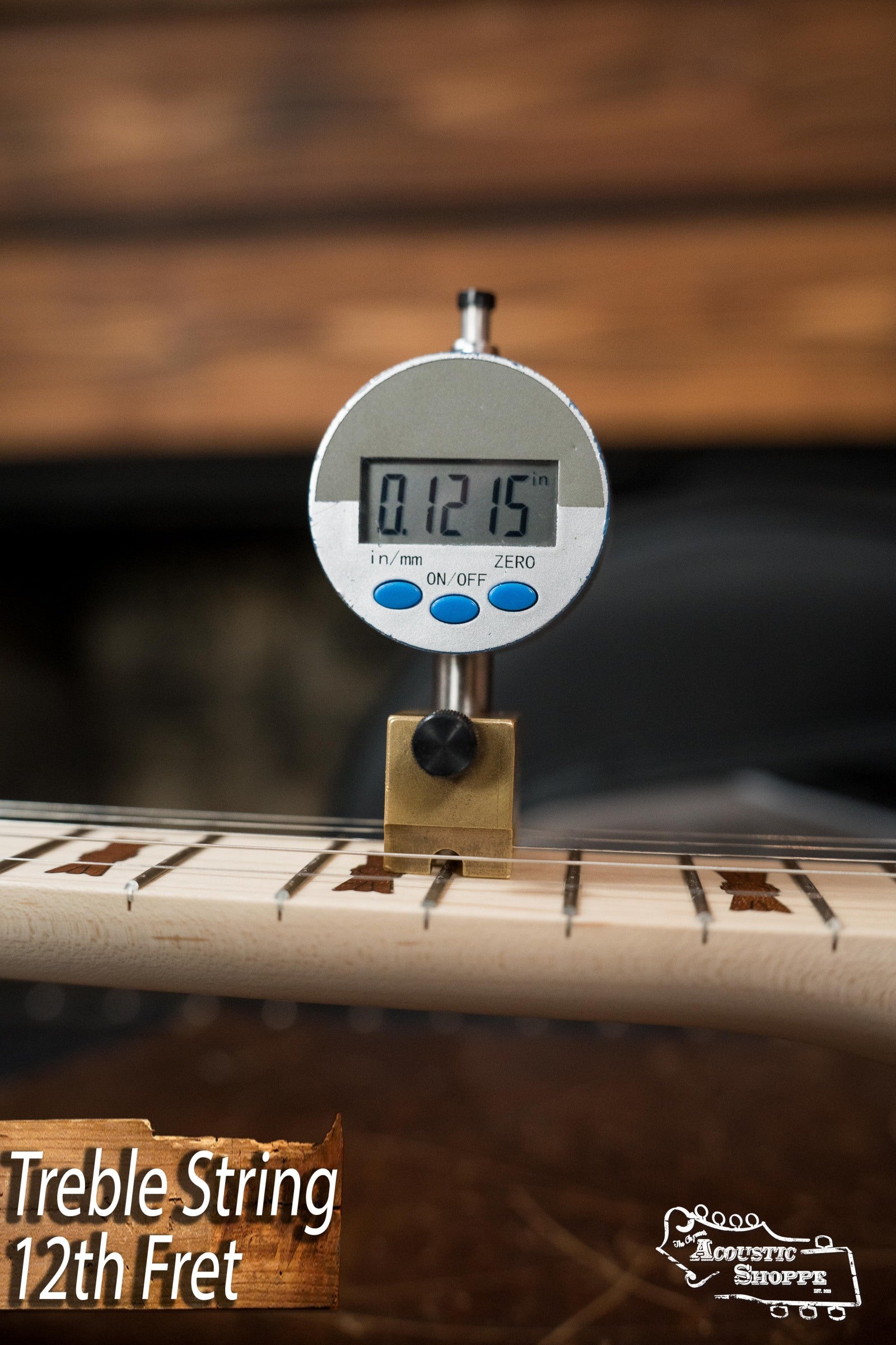 Close-up of a digital gauge measuring 0.1215 inches at the 12th fret (treble string), labeled Treble String 12th Fret and Acoustic Shoppe, similar to measurements on a Deering Banjos Goodtime Deco 5-String Banjo #52407.