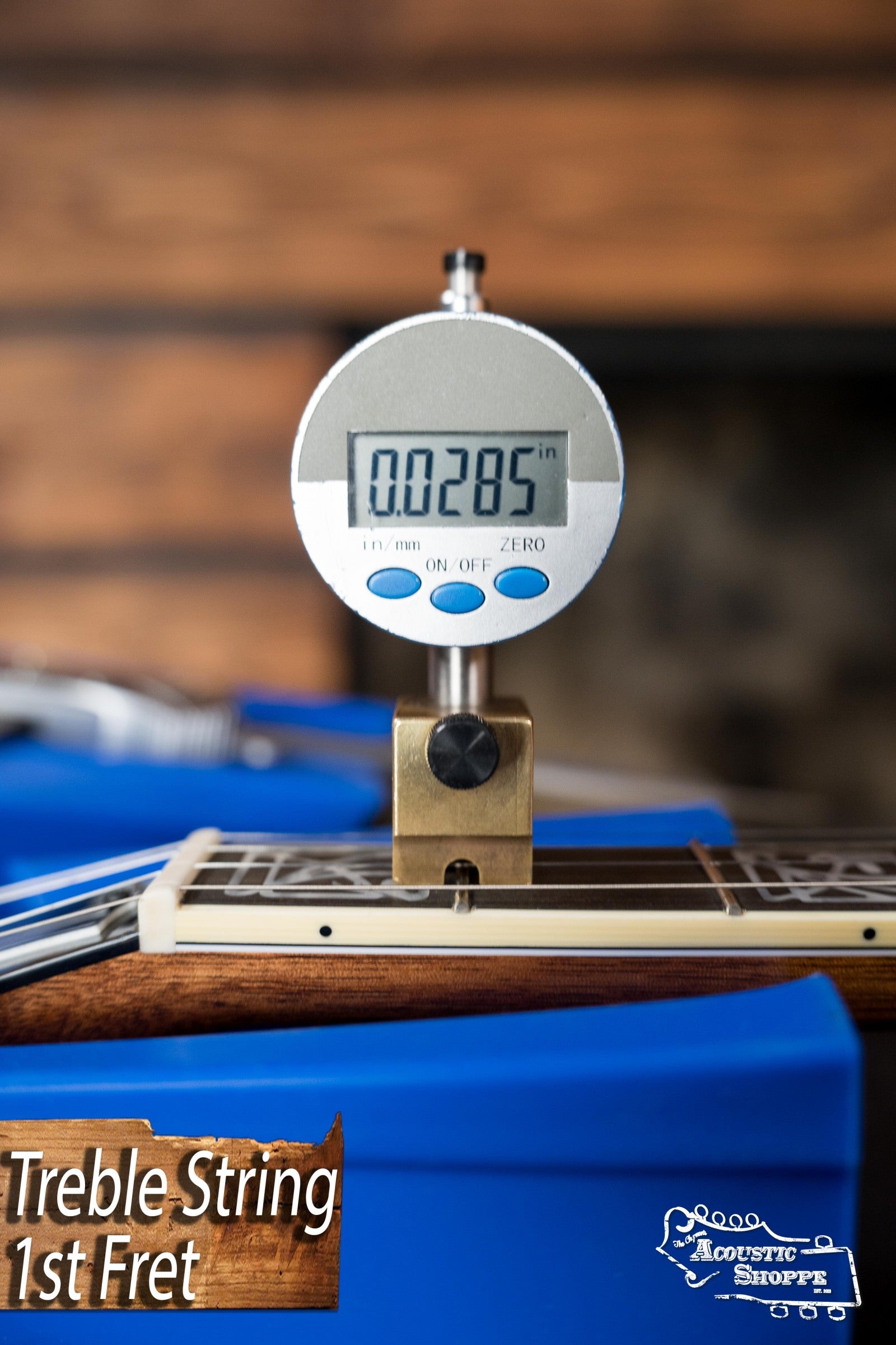 A digital caliper reads 0.0285 for Treble String 1st Fret on the Deering Tony Trischka Silver Clipper Resonator Banjo w/Spikes (Deering Banjos), shown by Acoustic Shoppe—ideal setup for bluegrass or resonator banjo players.