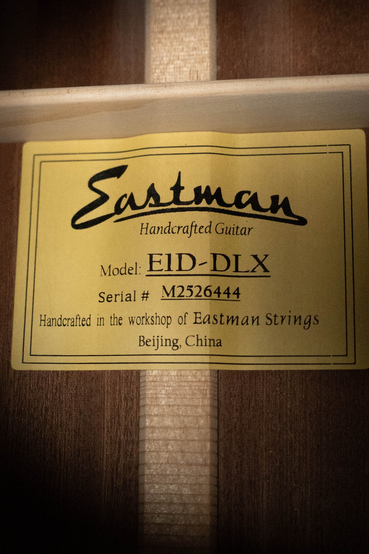 A yellow label inside this guitar reads: Eastman Guitars E1D-DLX Sitka/Sapele Dreadnought Guitar w/Fishman Pickup #6444, handcrafted in the Eastman workshop, Beijing, China.