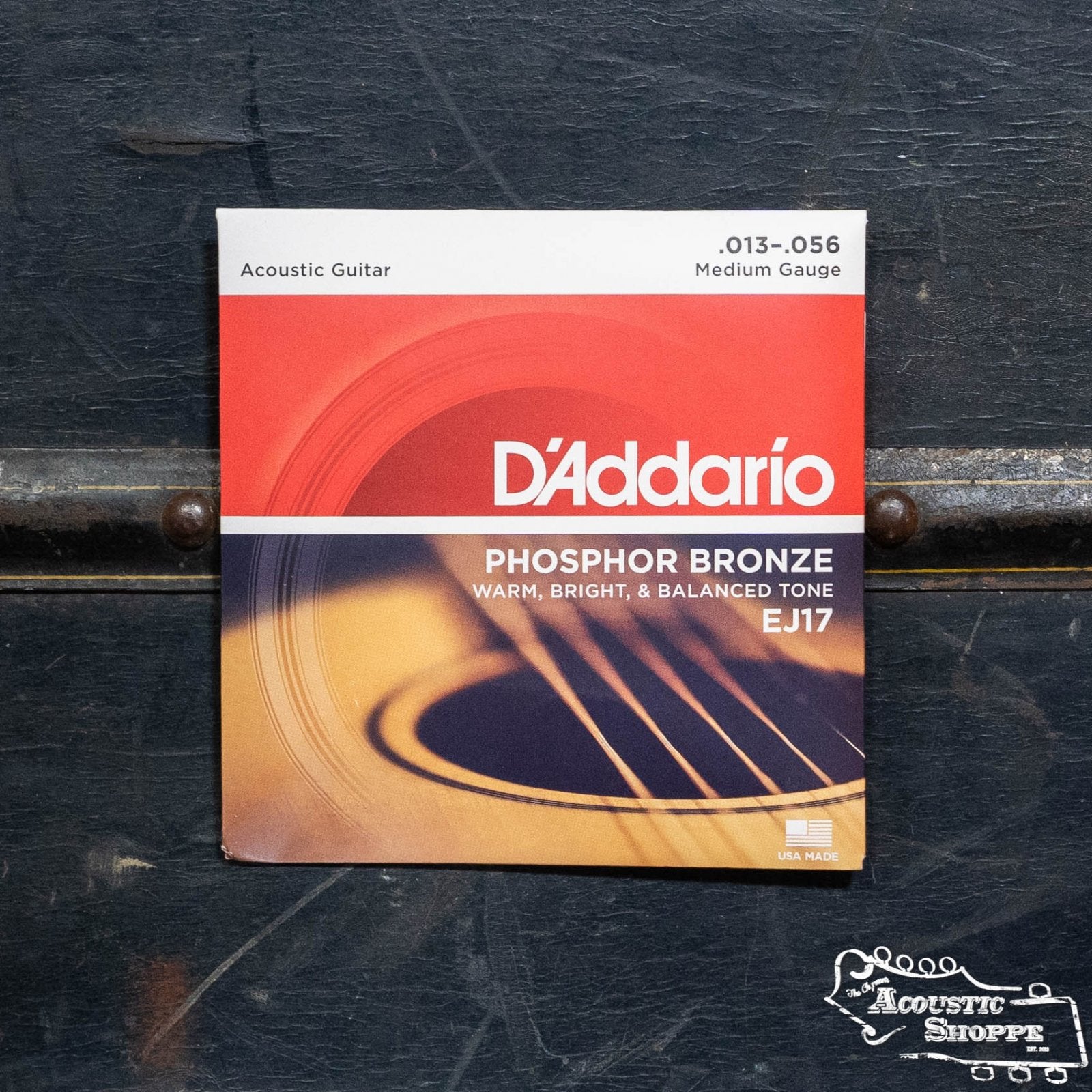 D'Addario EJ17 Phosphor Bronze Acoustic Guitar Strings Medium 13-56 offer a rich tone, ideal for heavy strumming, and feature an orange-red pack with The Acoustic Shoppe logo.