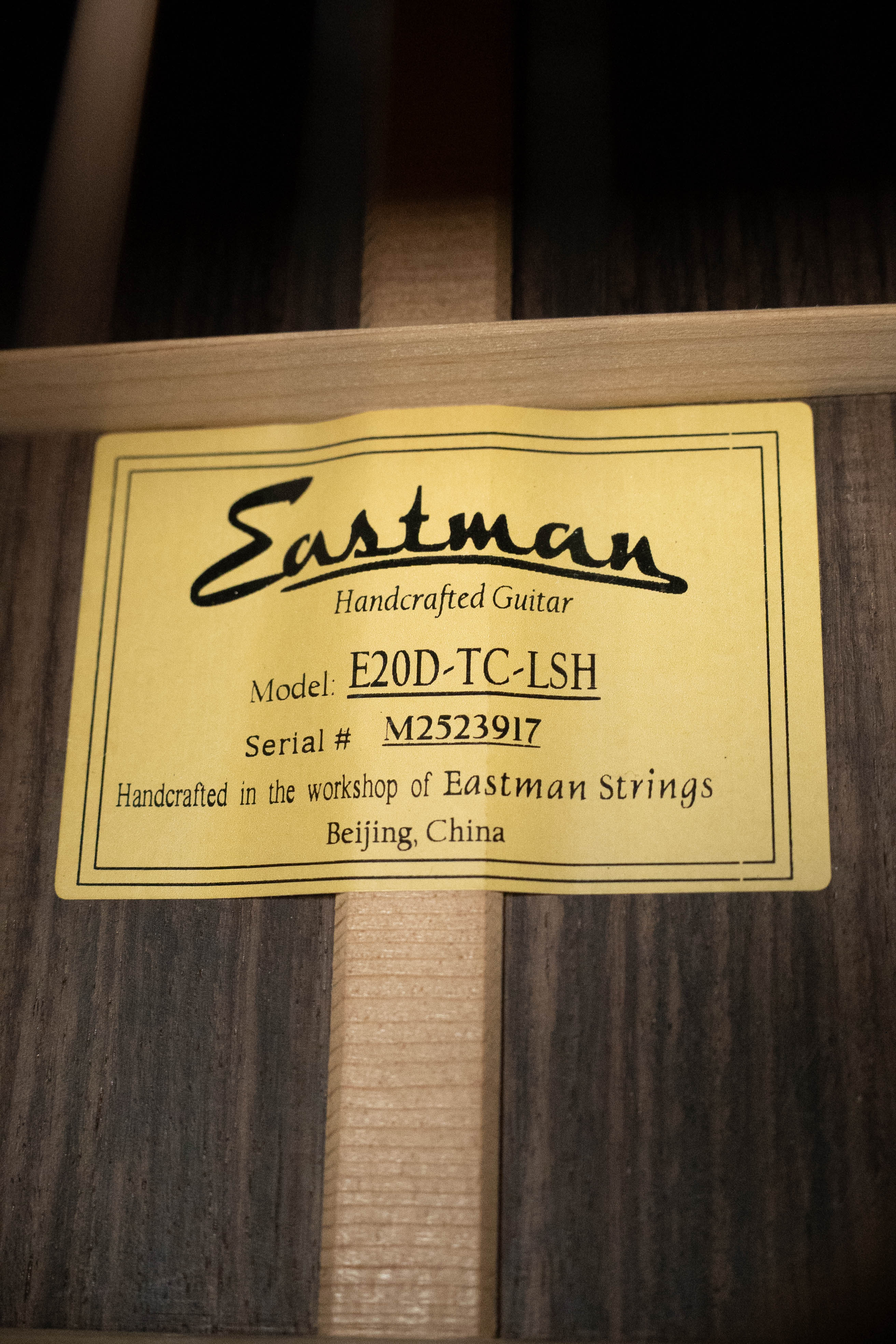 A yellow label inside this guitar reads: Eastman E20D-LSH-TC #3917. Handcrafted by Eastman Guitars in Beijing, China, it features a thermo-cured Adirondack spruce top and rosewood back and sides with a large soundhole design.