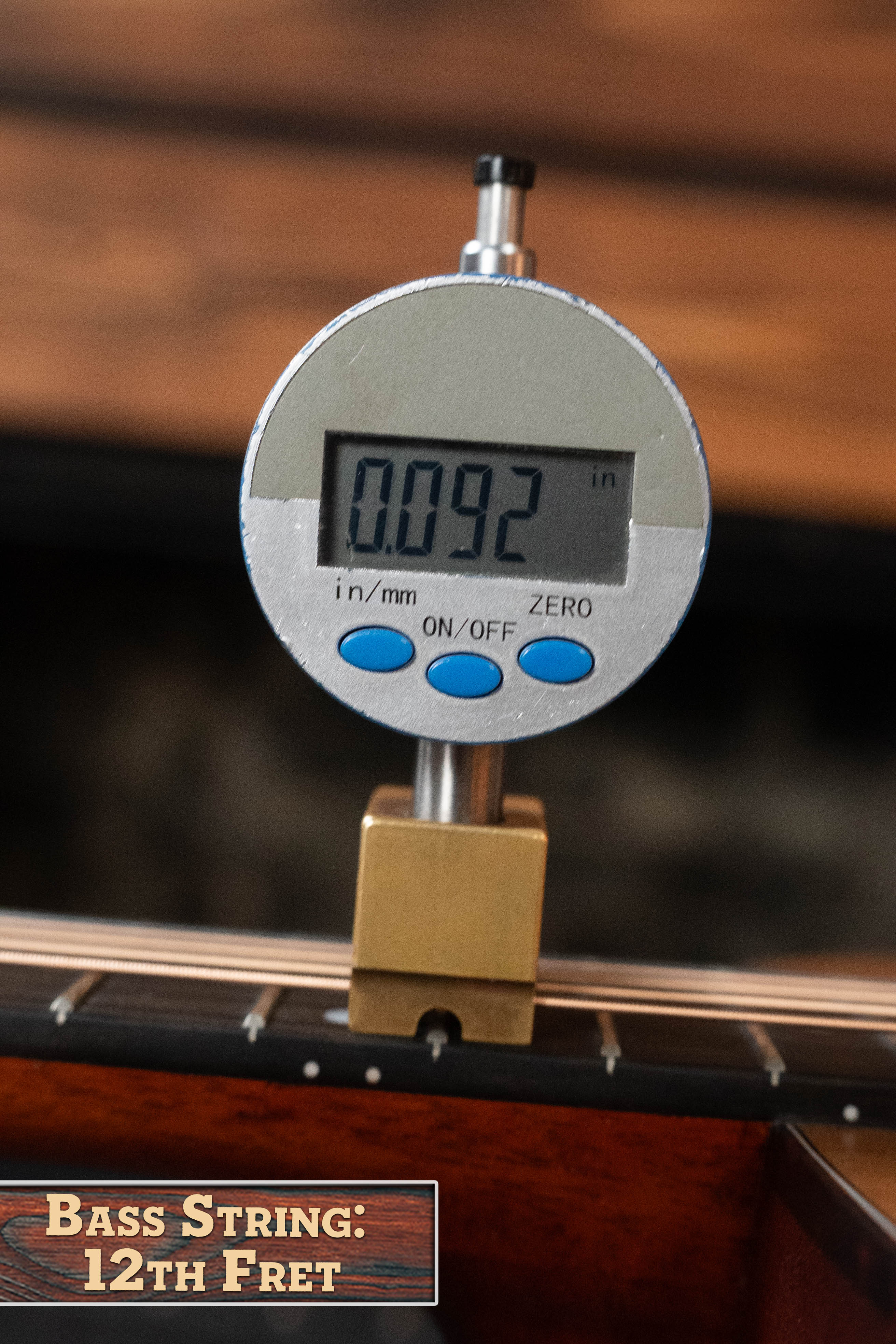 A digital caliper measures the 12th fret string height at 0.092 inches. Label below: Eastman Guitars E2OM Cedar/Sapele Orchestra Model Acoustic Guitar #9002—12th Fret.