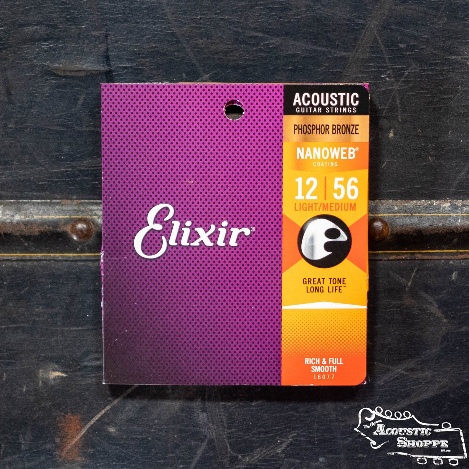 An Elixir 16077 Acoustic Nanoweb Phosphor Bronze Light/Medium 12/56 guitar string set by Elixir is shown on a dark background—ideal for acoustic guitars and available at Eastman dealers or your local music shop.