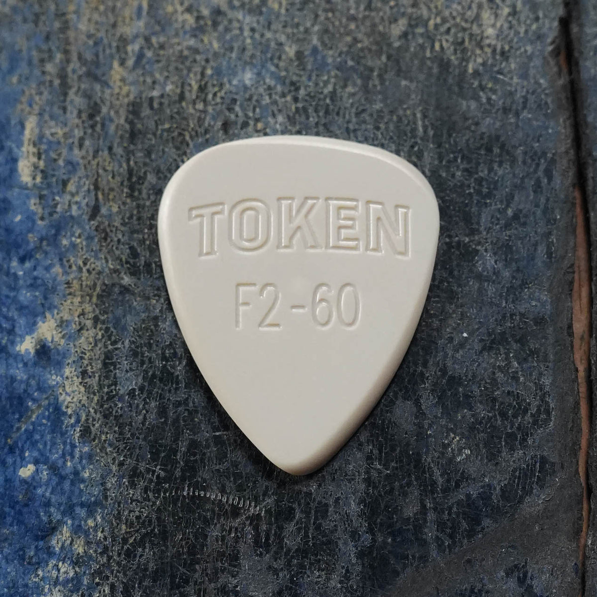 Token F2-60 TAN Flatpick, 1.5mm, teardrop shape, front view, beige finish with embossed logo and model.