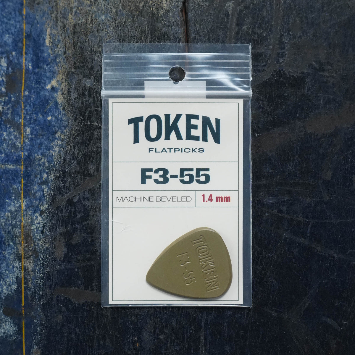 Token F3-55 Flatpick, olive green teardrop 1.4mm guitar pick in a clear plastic retail bag.