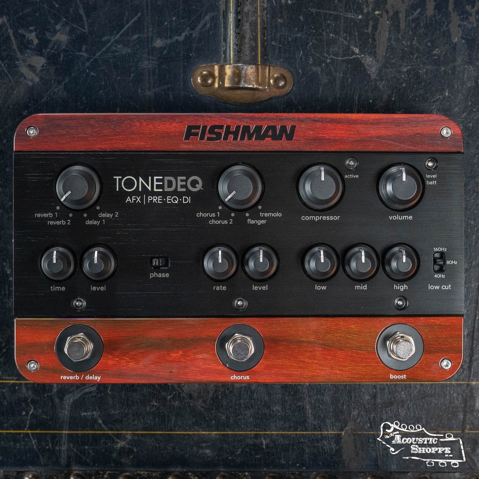 The Fishman ToneDEQ Preamp EQ (PRO-DEQ-AFX) by Fishman features black knobs, switches, and dials for effects like compressor, chorus, reverb, delay, and EQ—perfect for acoustic musicians—displayed on a dark textured surface.