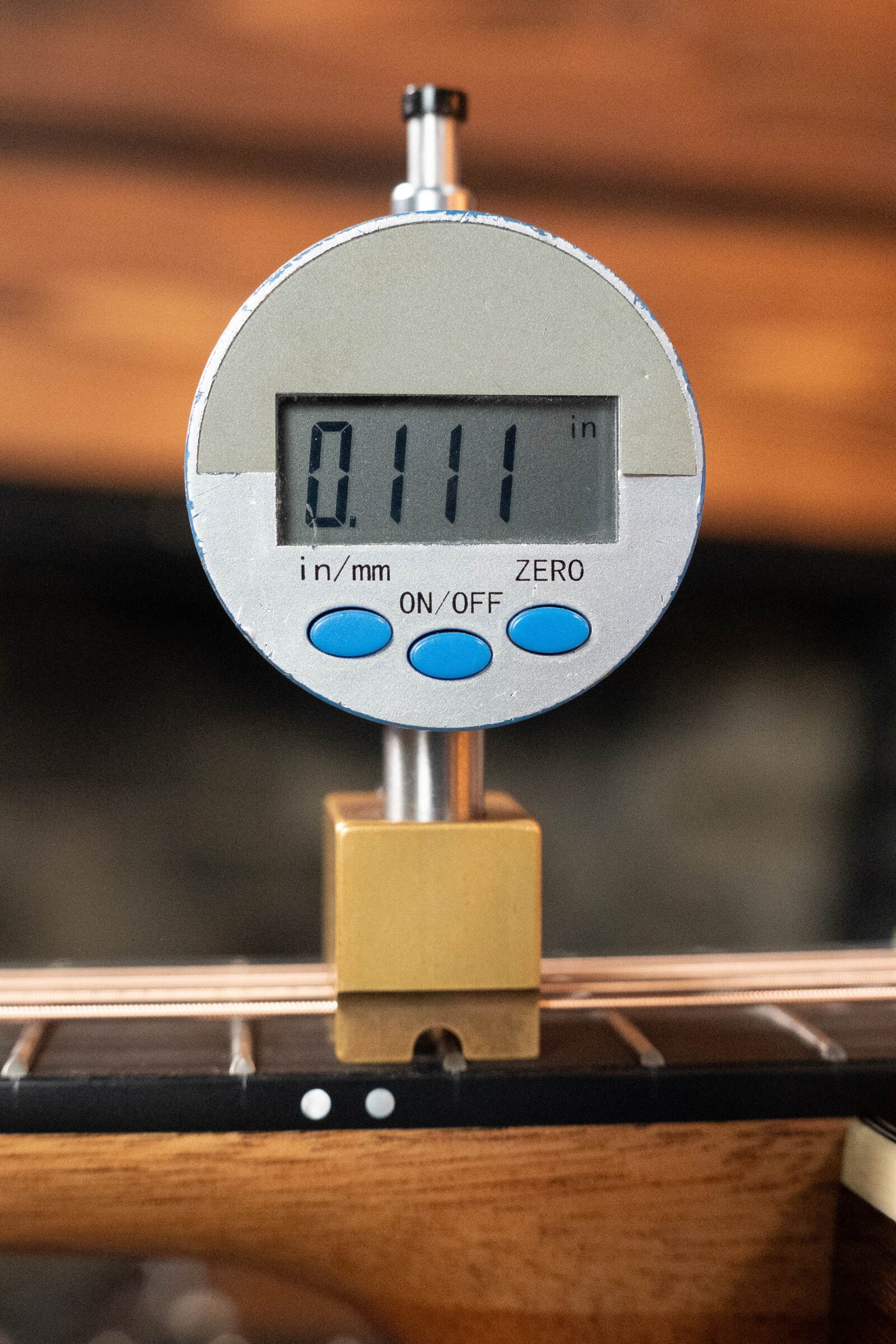 A digital gauge shows a 0.111 inch string height above the fretboard on a Furch Masters Choice Green SB Dc-SR AA Sitka/AA Indian Rosewood Dreadnought Cutaway Sunburst Guitar w/LR Baggs Pickup #0020.