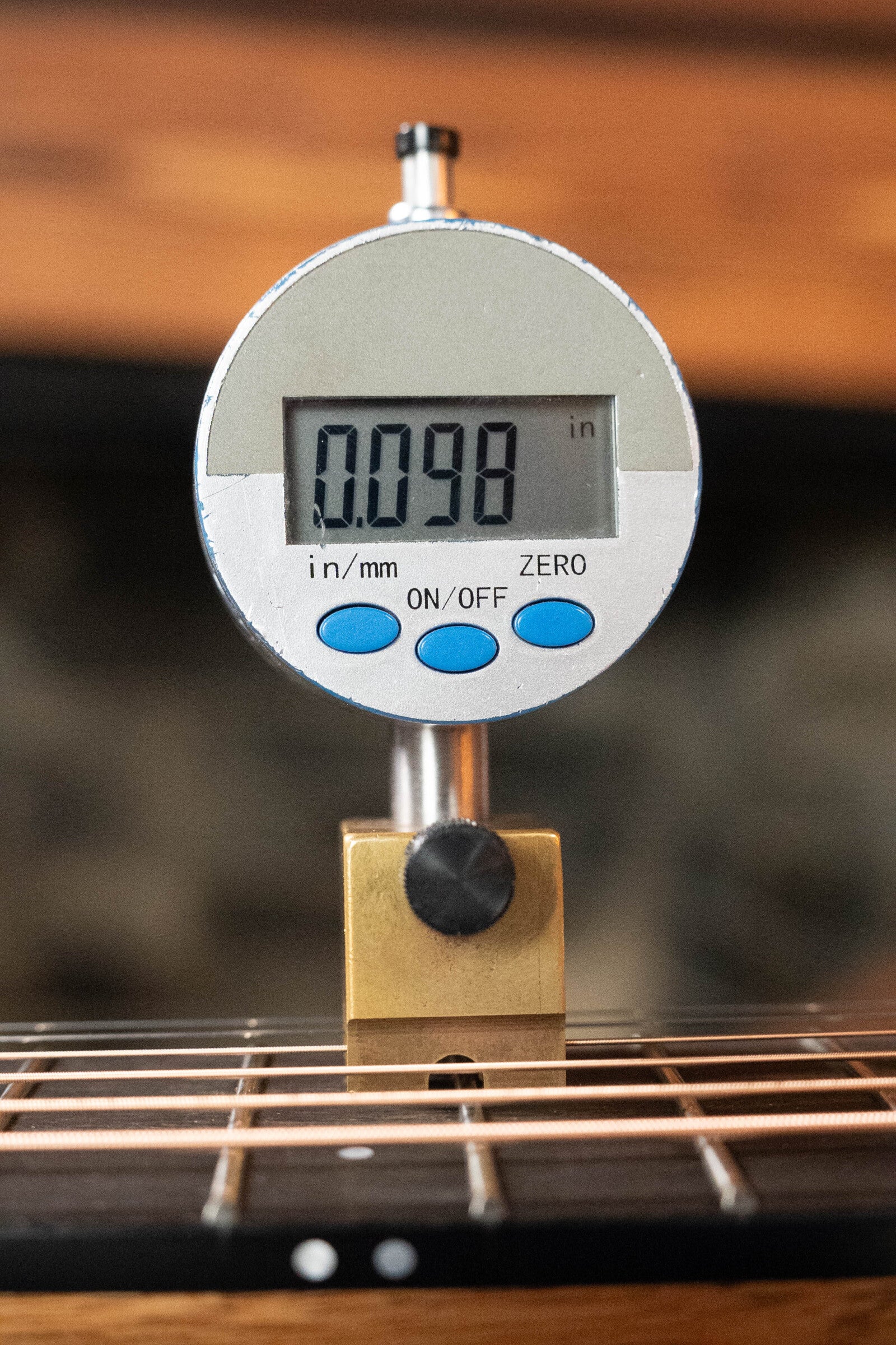 A digital gauge shows 0.098 inches while measuring string height above the Sitka spruce top on a Furch Masters Choice Green SB Dc-SR AA Sitka/AA Indian Rosewood Dreadnought Cutaway Sunburst Guitar w/LR Baggs Pickup #0020.