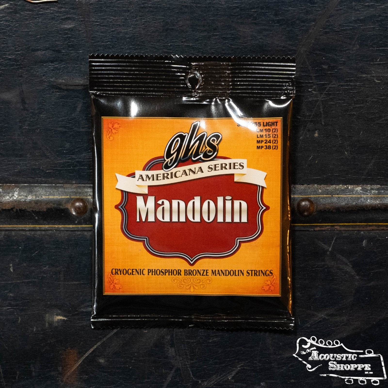 A packet of GHS A255 Americana Series Mandolin Strings - Light by GHS Strings, photographed on a dark surface. The orange pack has decorative borders and displays The Acoustic Shoppe logo in the bottom right corner.
