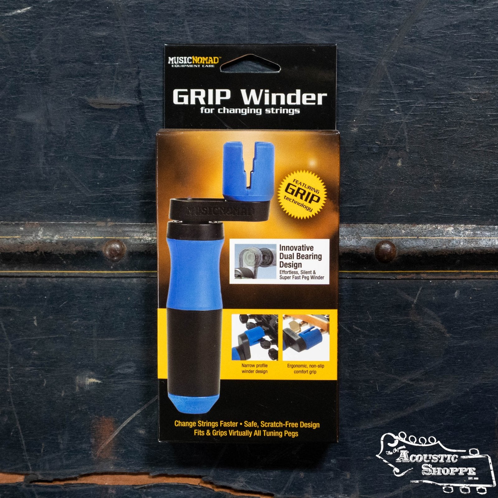 A Music Nomad Grip Winder (MN221) in blue and black packaging stands upright against a dark background, with The Acoustic Shoppe logo in the bottom right corner.