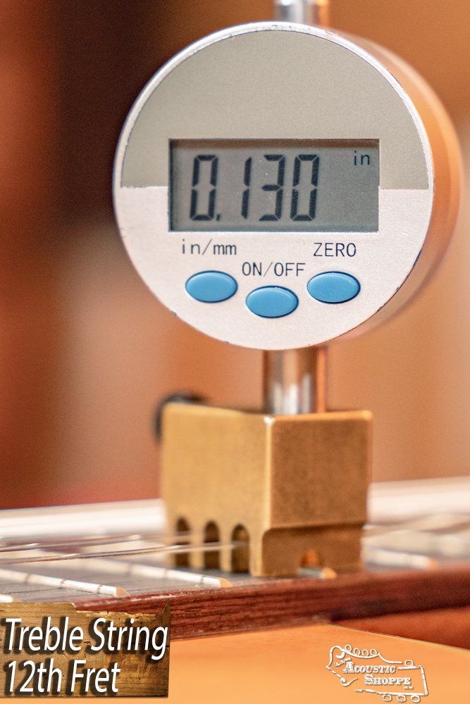 A digital gauge measures 0.130 inches above the treble string at the 12th fret of a Cordoba C3M Red Cedar/Mahogany Classical Guitar #8691. The display is close-up with “Treble String 12th Fret” and the Acoustic Shoppe logo in the lower left corner.