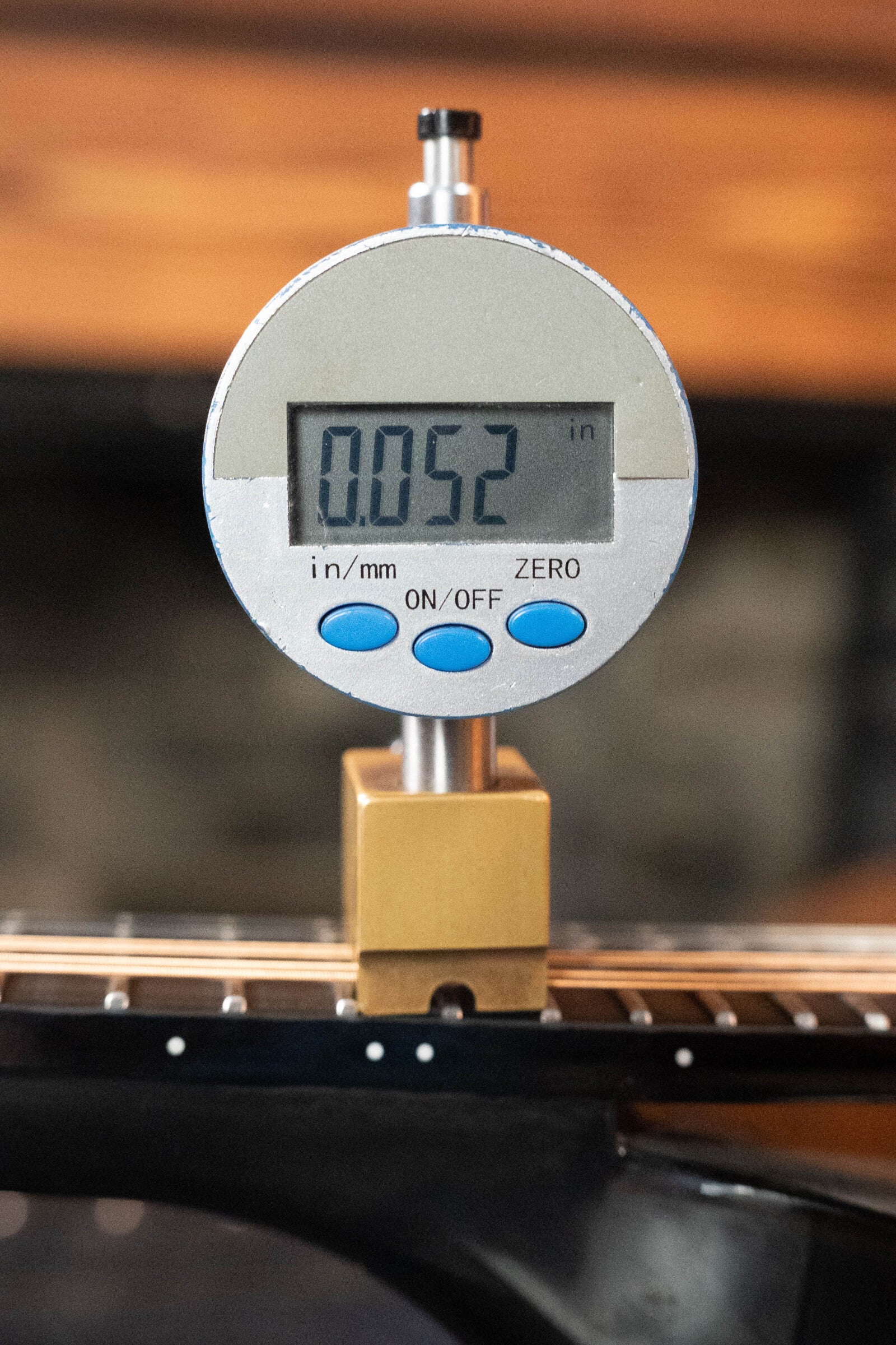 A digital caliper shows 0.052 inches when measuring the string height above the fretboard on a KLOS Guitars CT_MA_DAE_EQ Full Carbon Unidirectional Black A-Style Mandolin w/KLOS EQ Pickup (#4889).