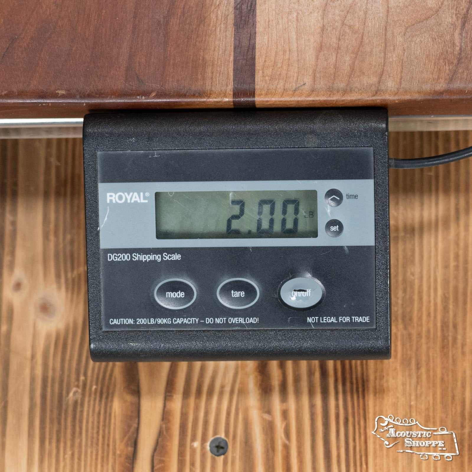 A digital Royal shipping scale reads 2.00 pounds while resting on wood, recalling the solid spruce top of The Loar LM-110E-BRB "Honey Creek" A-Style Brownburst Mandolin w/Pickup #0688 from The Loar.