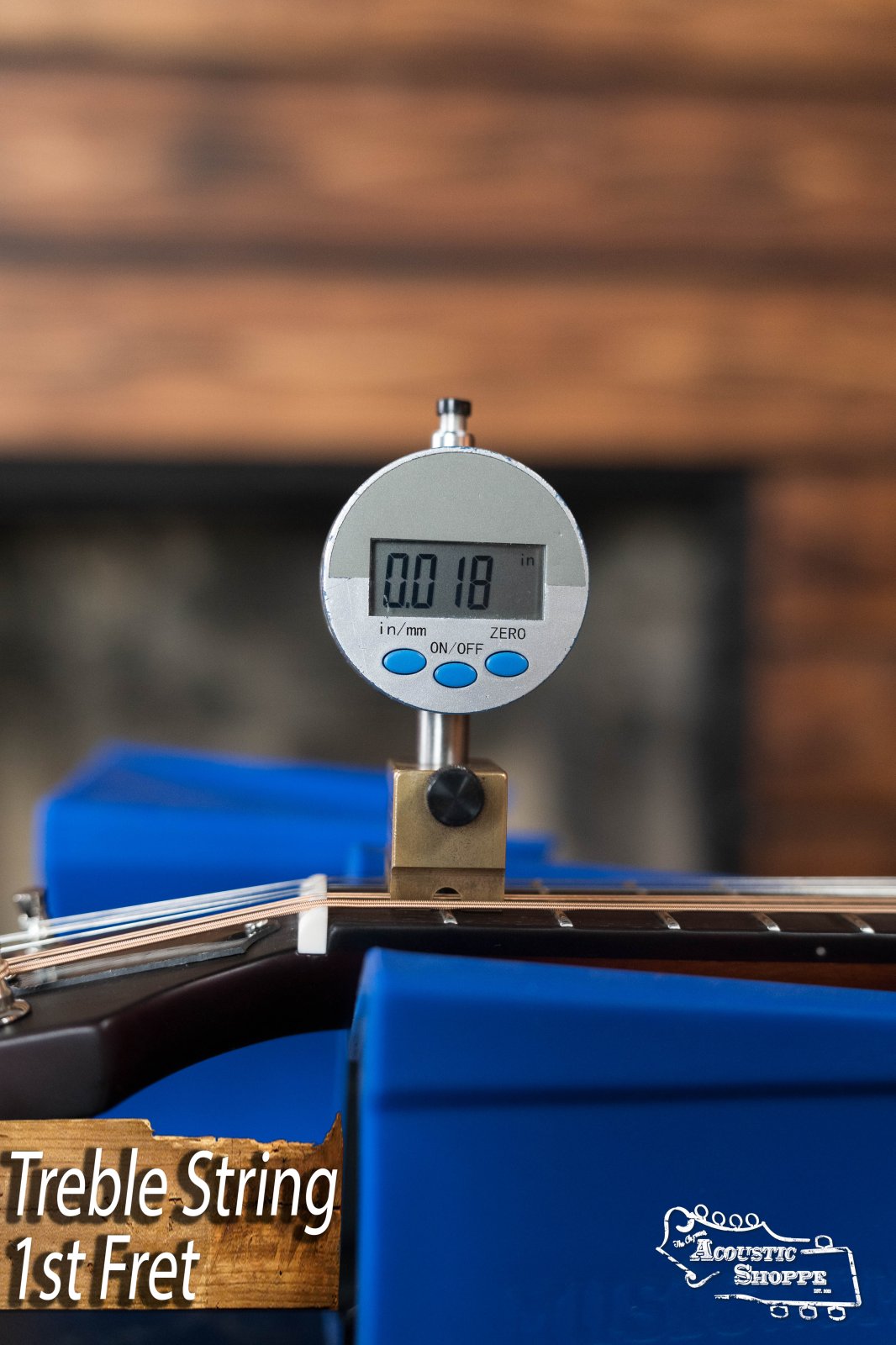 A digital gauge shows the treble string action at the 1st fret as 0.18 mm on The Loar LM-110E-BRB "Honey Creek" A-Style Brownburst Mandolin w/Pickup #0688, which features a solid spruce top and rests on a blue Acoustic Shoppe support.