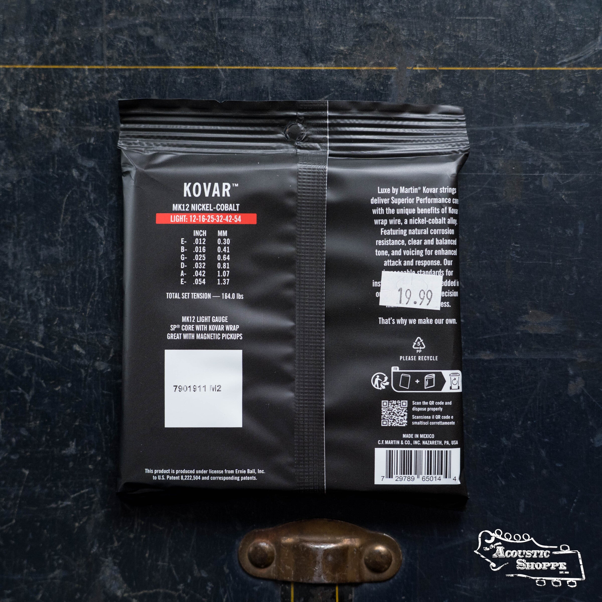 A packet of LUXE By Martin Kovar Light Strings 41Y23MK12 from Martin & Co. lies flat on a dark surface, showing product details, price, barcode, and The Acoustic Shoppe logo. Enjoy clear, balanced tone from these premium Kovar alloy guitar strings.