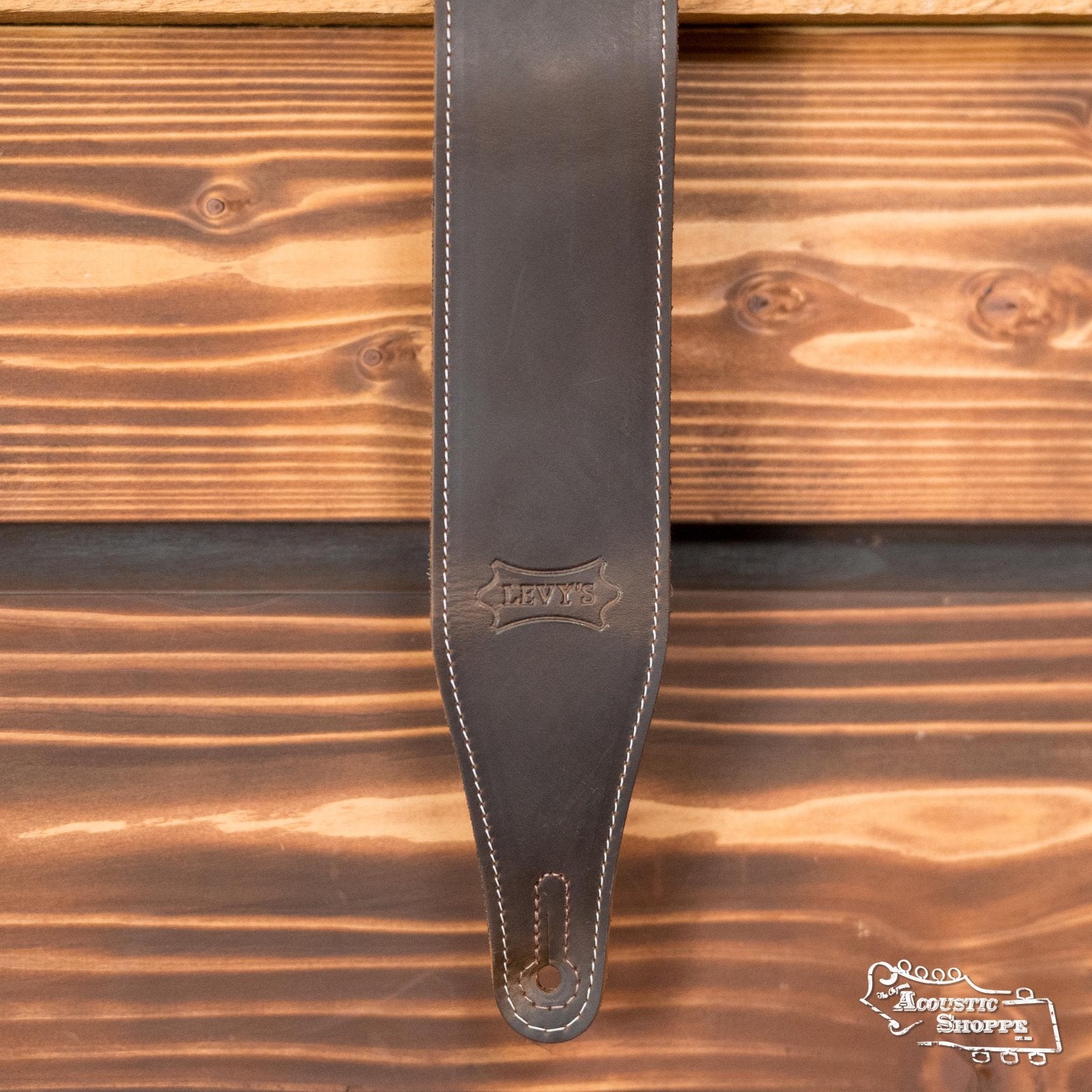 Levy's 2.5" Pull-Up Butter Leather Guitar Strap - Brown (M17BAS-DBR) by Levy's Leather features dark brown leather with white stitching, an embossed logo near the end, and a cutout slot for easy attachment—ideal for acoustic instruments.