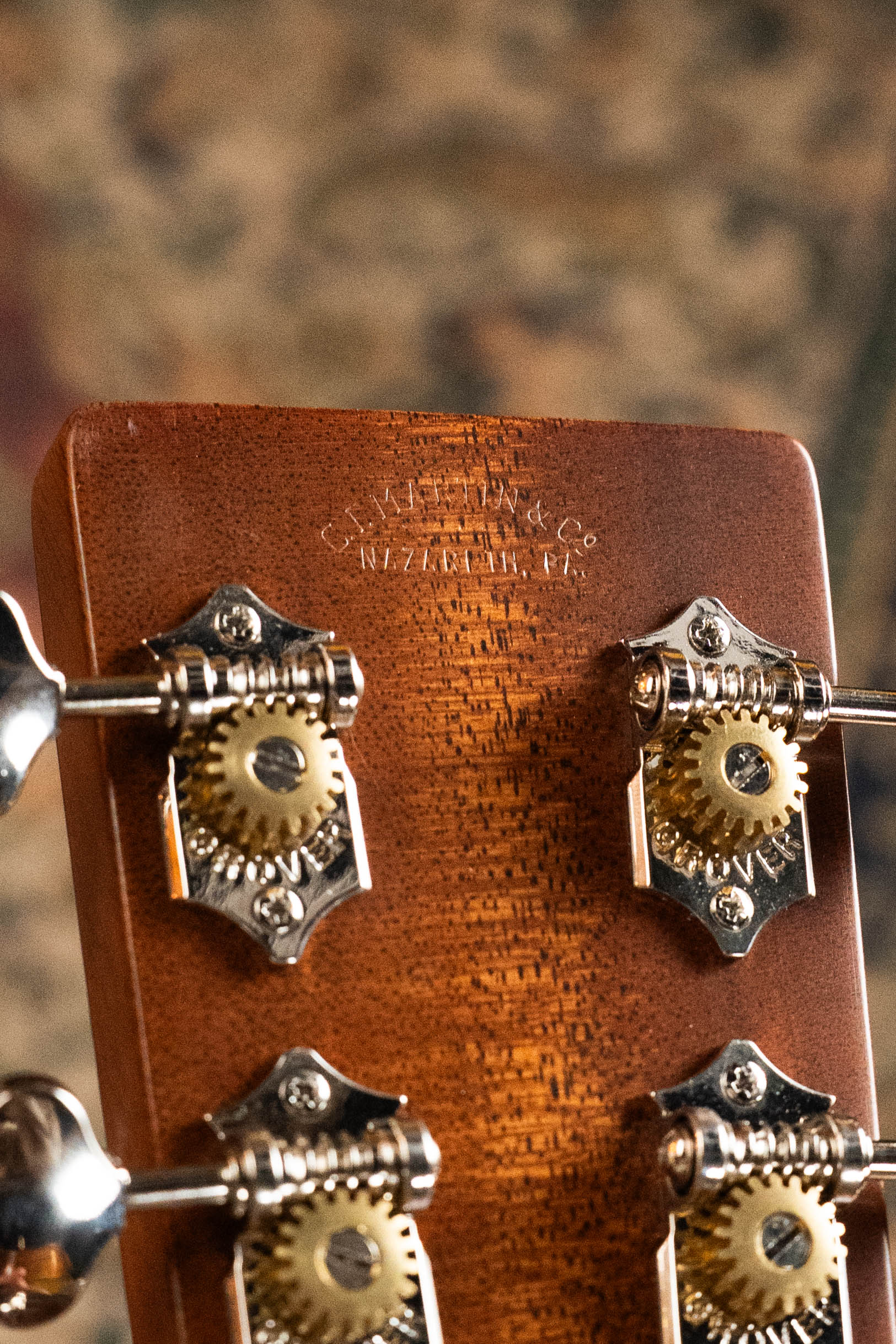 Close-up of the back of a vintage Martin & Co. guitar headstock, showing metal tuners and the engraved Nazareth, PA logo—crafted to perfection like the Martin Custom Shop D-18V Adirondack/Mahogany Dreadnought Acoustic Guitar #6905.