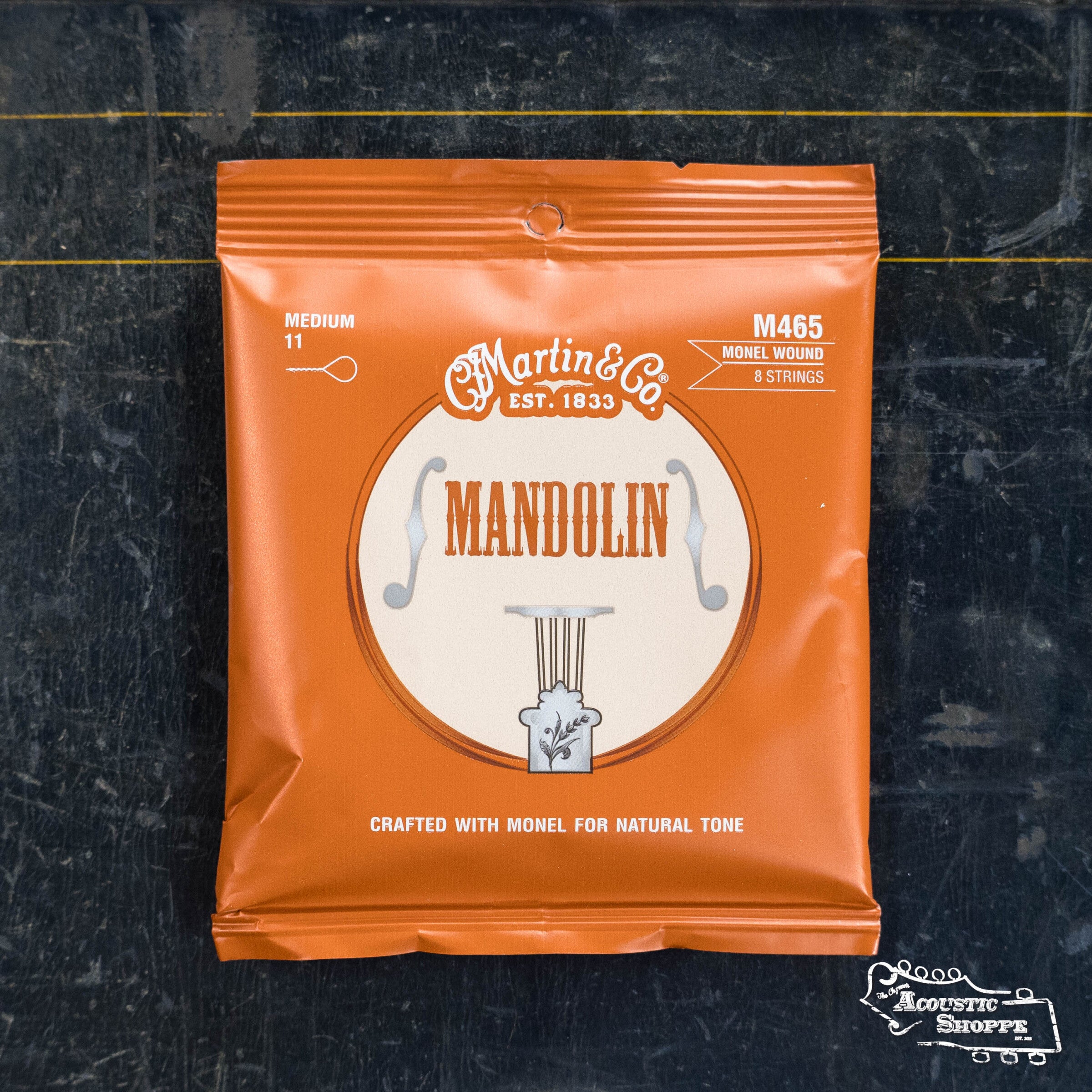 A Martin & Co. Medium Mandolin Strings Monel 41Y18M465 orange packet for 8-string instruments, labeled "crafted with monel for a resonant tone," sits on a dark background with The Acoustic Shoppe logo in the corner.