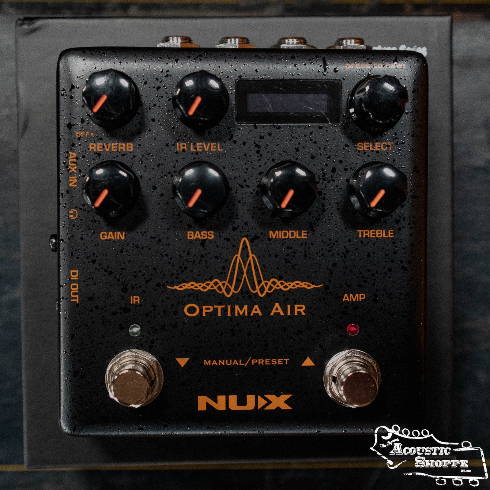 A black NUX NAI-5 Optima Air Acoustic Simulator & IR Loader with multiple knobs, buttons, two footswitches, and water droplets on its surface, featuring The Acoustic Shoppe logo in the bottom right corner.