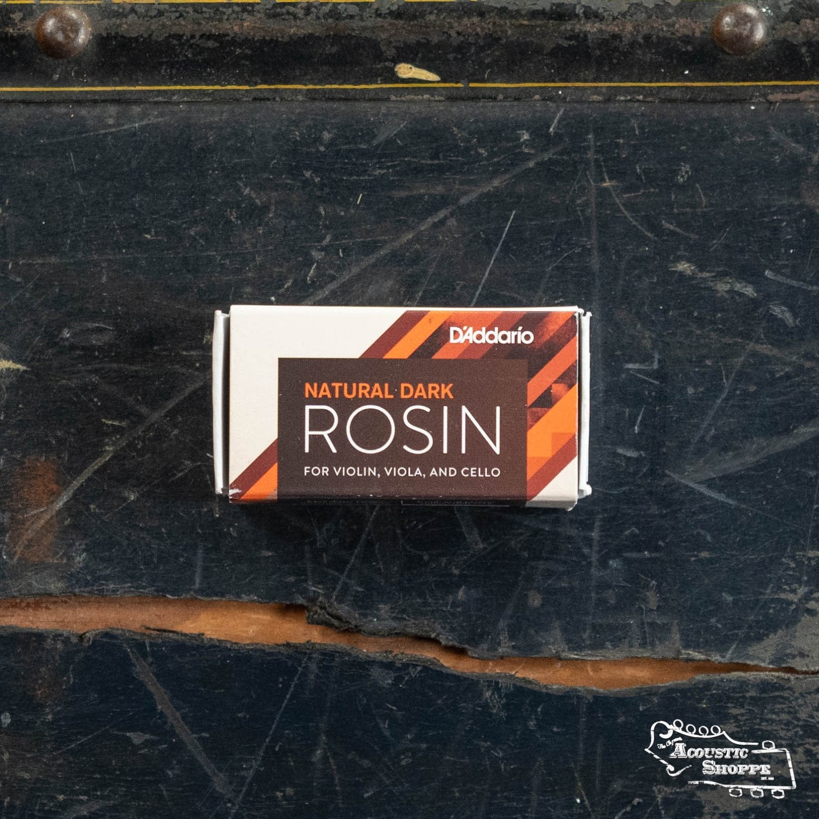 A box of DAddario Natural Rosin (VR200 VR300), perfect for violin, viola, or cello bows, sits on a worn dark wood surface with the white Acoustic Shoppe logo in the lower right corner.