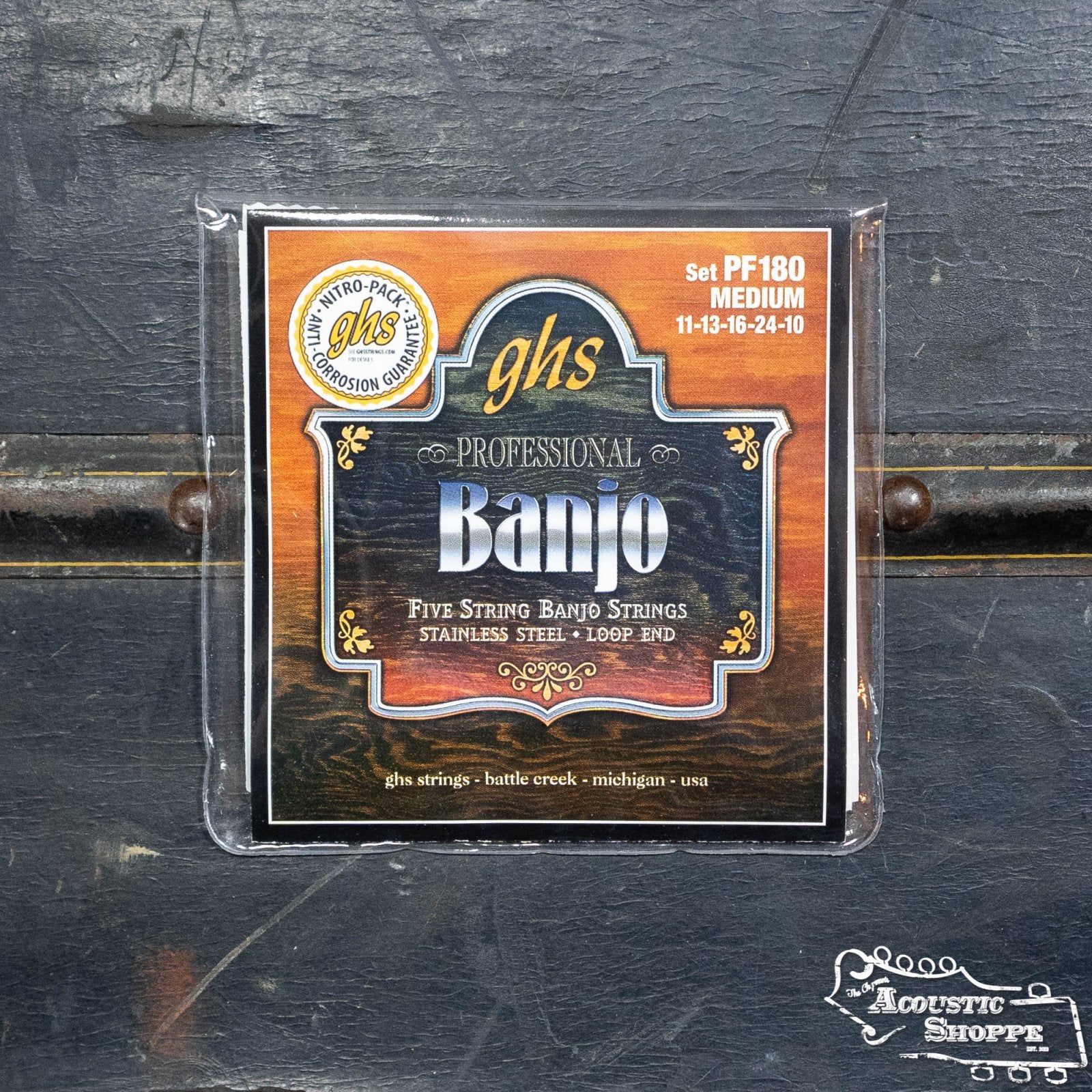 GHS Strings PF180 Stainless Steel Medium Banjo Strings for 5-string banjos, gauges 11-13-16-24-10, feature an ornate gold and orange label with detailed branding.