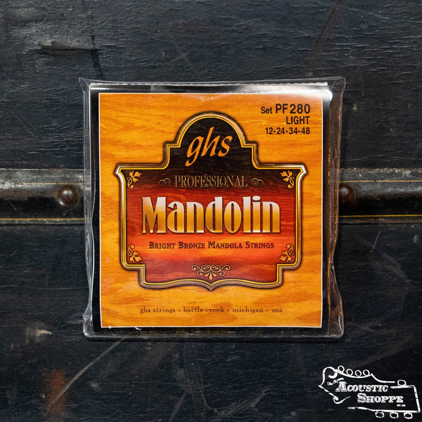 A pack of GHS Strings PF280 Bright Bronze Mandola Loop End Strings - Light (12-24-34-48), in orange packaging on a black textured surface, with The Acoustic Shoppe logo in the corner.