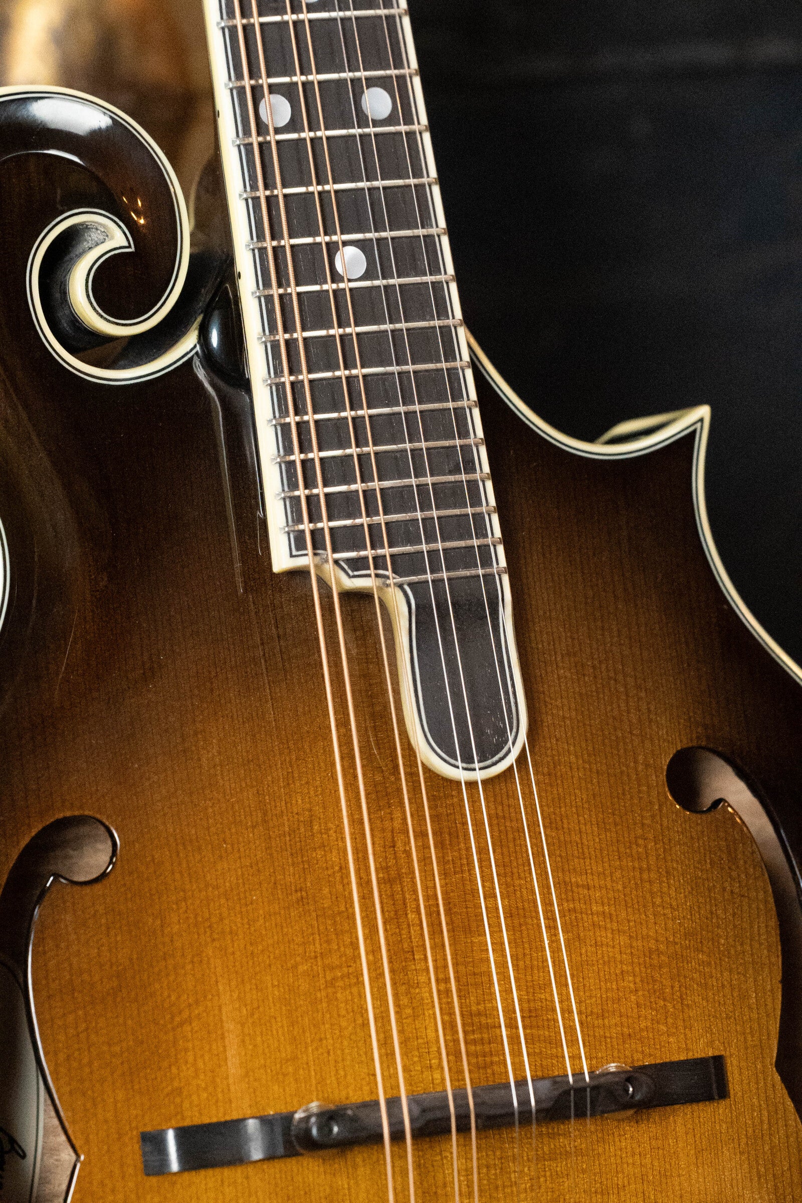 Close-up of a Bourgeois *Pre-Order 25% Deposit ONLY* M5-F-SB/M5-A-SB F-Style or A-Style Mandolin, featuring an Aged-Tone Adirondack/Maple sunburst finish that highlights its elegant f-holes, curved body, and detailed craftsmanship.
