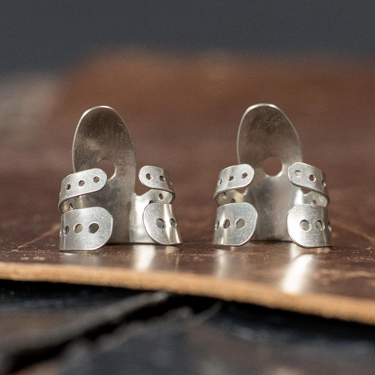 Two ProPik Angled Extra Comfortable Nickel Split Wrap #2 Fingerpicks (2-pack) with layered bands and small holes, shown upright on a brown textured surface, brand: ProPik.