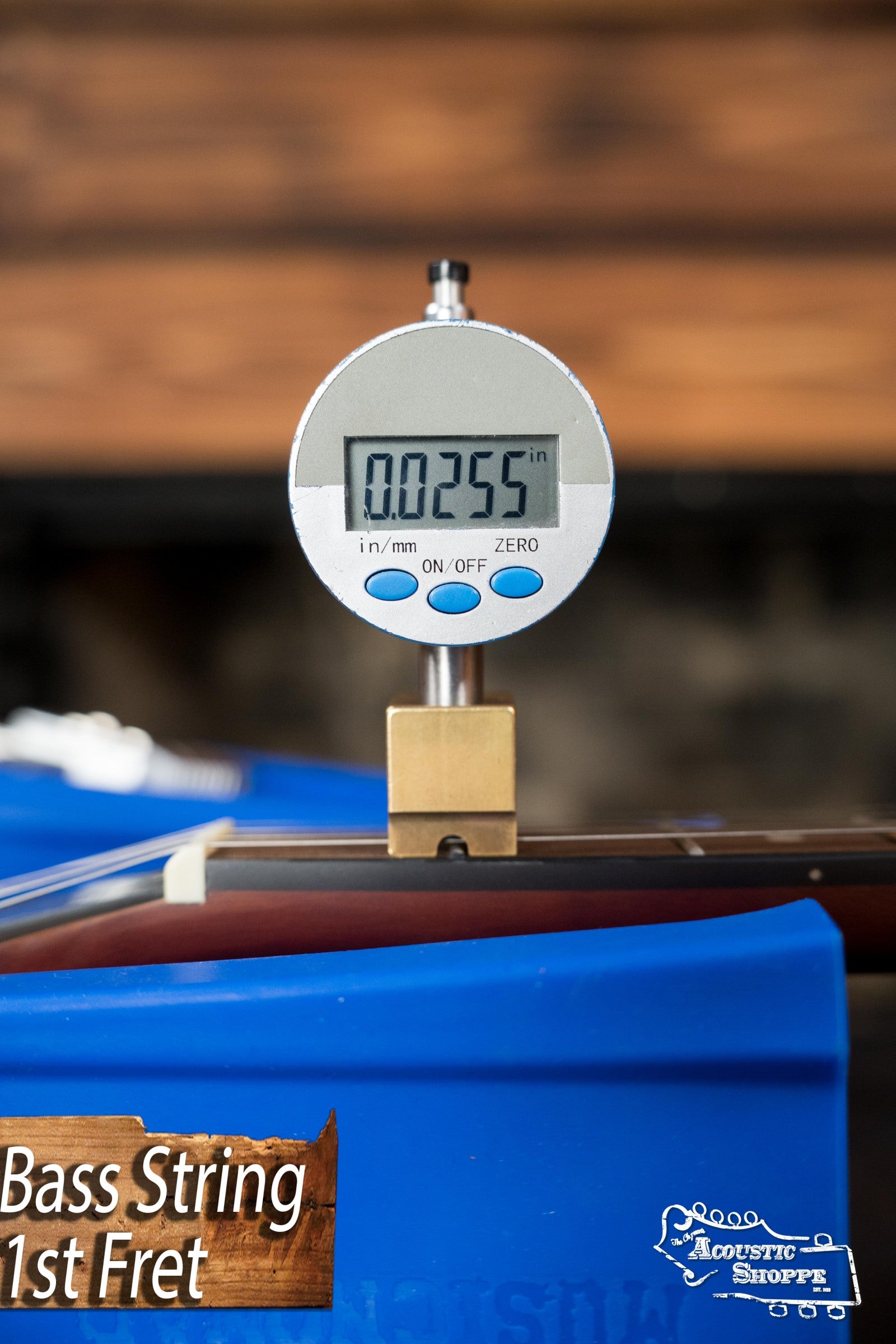 A digital gauge reads 0.0255 inches while measuring string height at the 1st fret, with Recording King and Acoustic Shoppe logos visible, as seen on the Recording King RKH-05 Dirty 30s Resonator Banjo #2563.